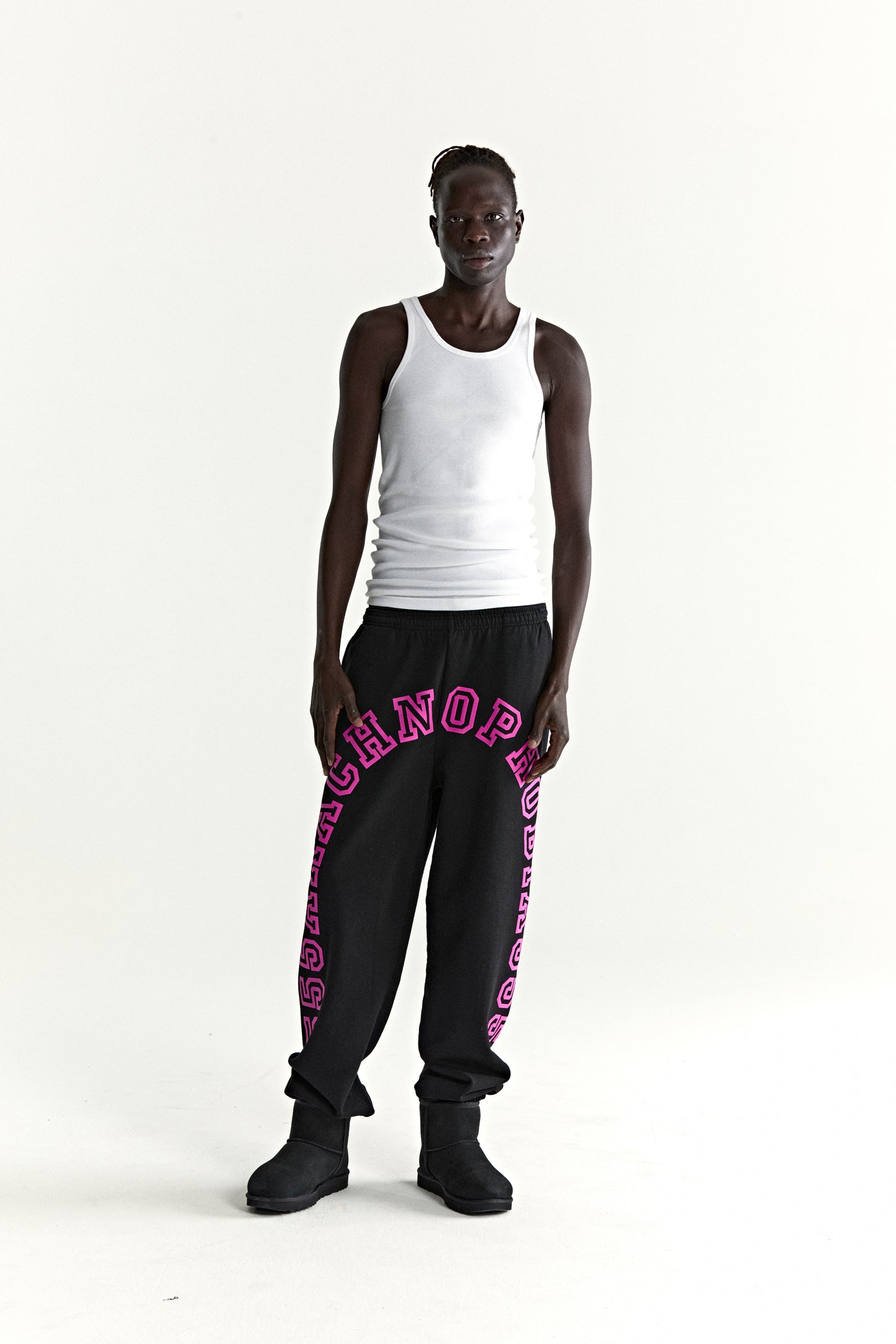 Black ARACH sweatpants with pink arched text print, elasticized waistband and cuffs, worn by a model.