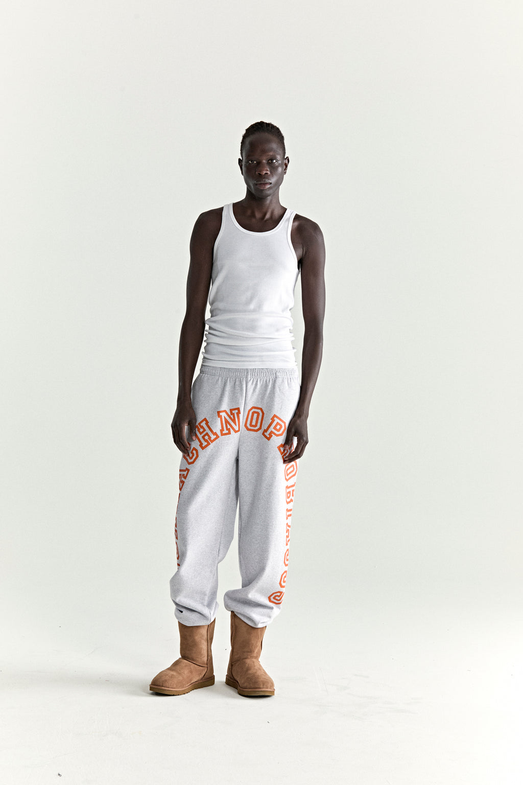 Light grey 13oz cotton fleece ARACH sweatpants with orange arched text print, elasticized cuffs.