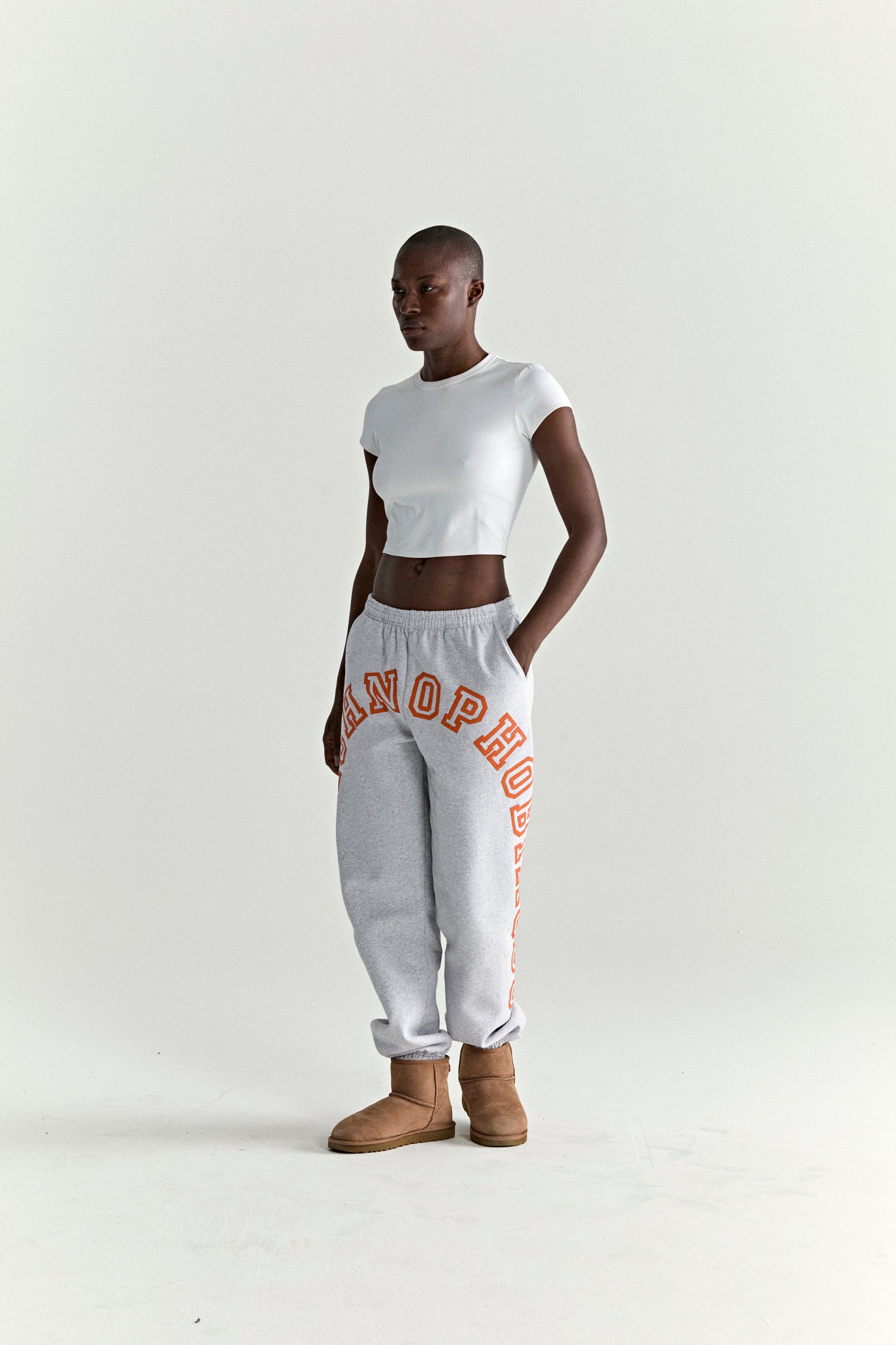 Grey 13oz cotton fleece ARACH SWEATPANT with arched orange puff/discharge print, elastic cuffs, and drawstring waist.