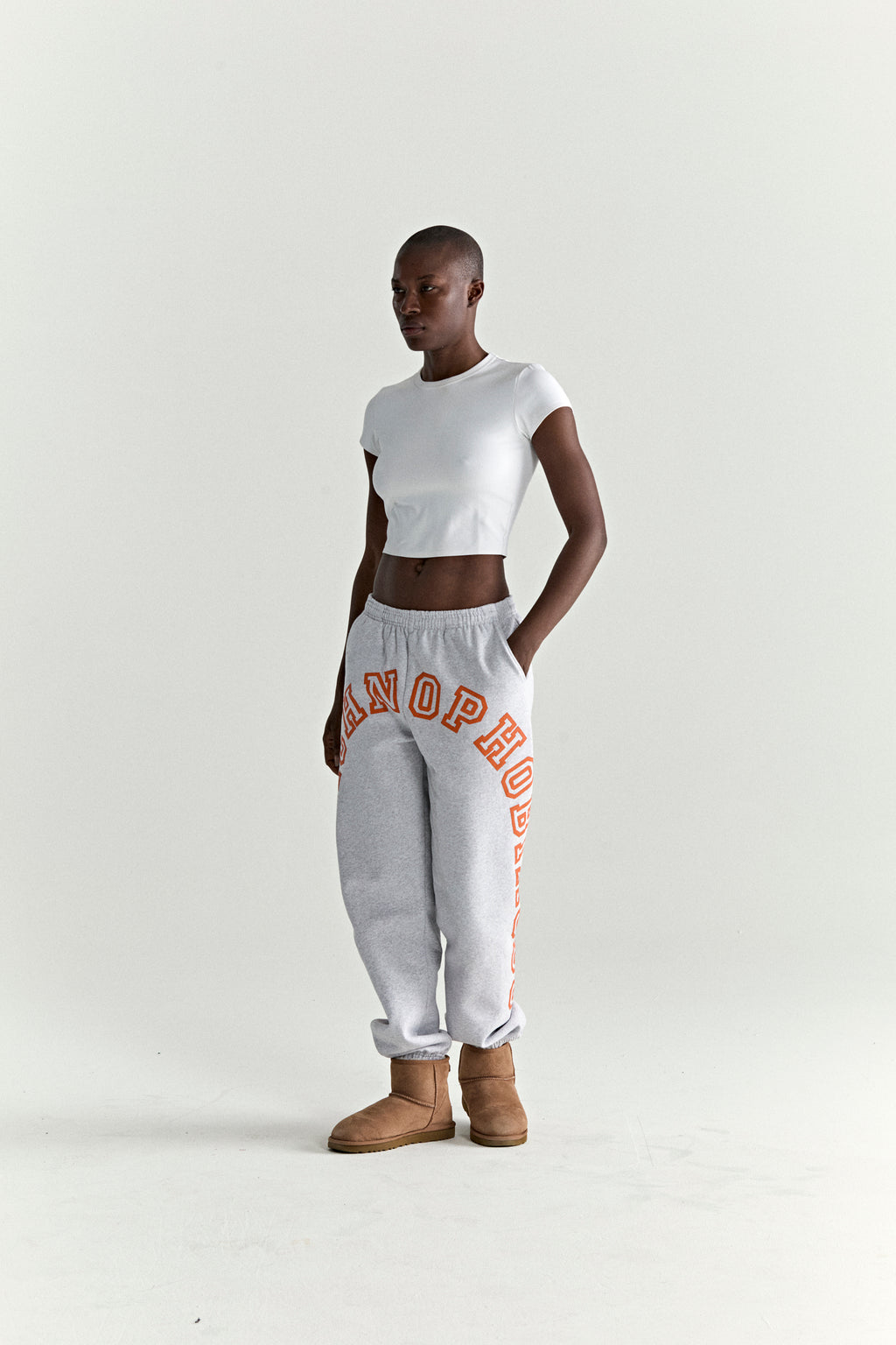 Grey 13oz cotton fleece ARACH SWEATPANT with arched orange puff/discharge print, elastic cuffs, and drawstring waist.