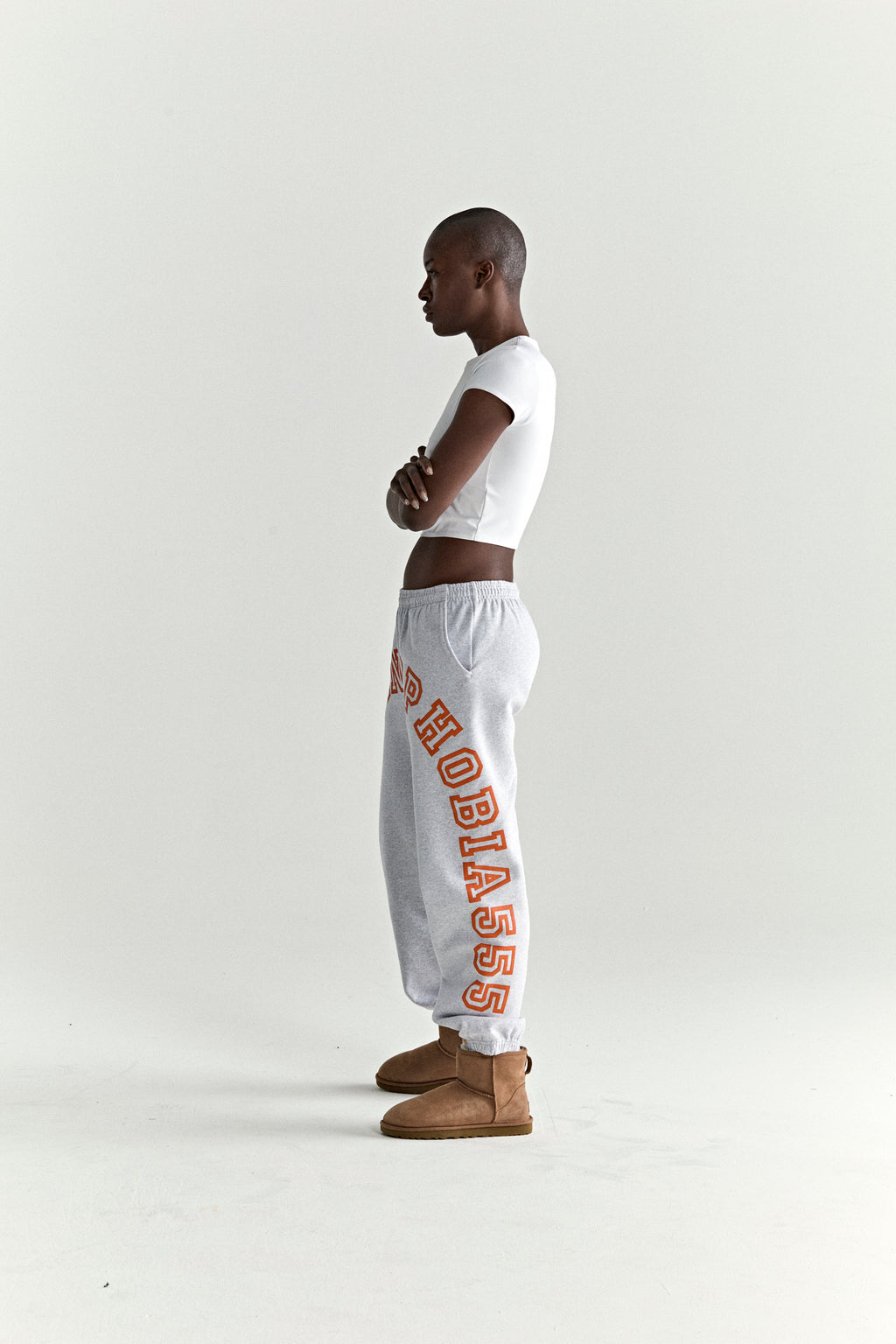 Grey 13oz cotton fleece sweatpants with arched orange "HOBIAS" text print, elasticized waistband, and cuffs.
