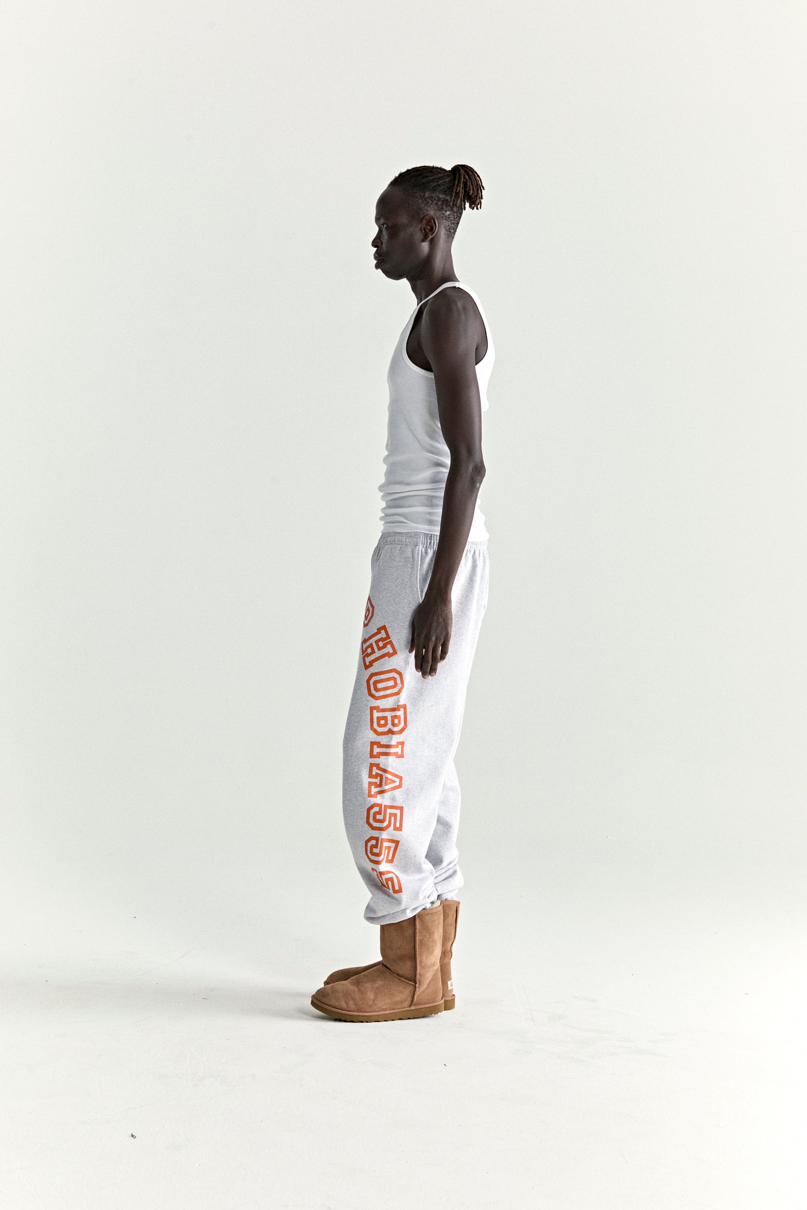 Light grey ARACH SWEATPANT, 13oz cotton fleece, with arched orange text print along crotch and leg.