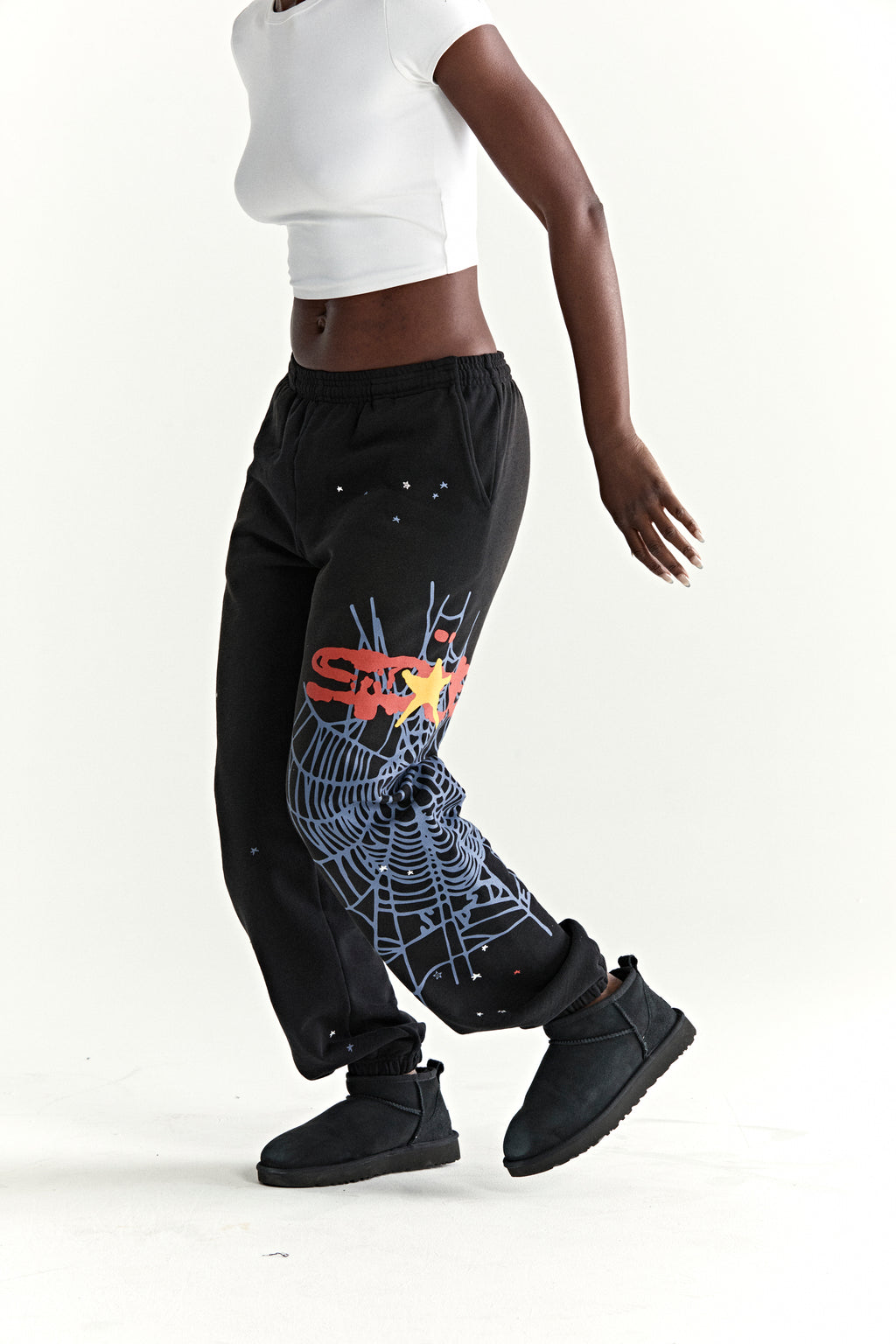 Black 13oz cotton fleece sweatpants with SP5DER web graphic, scattered stars, drawstring waist, and elasticized cuffs.
