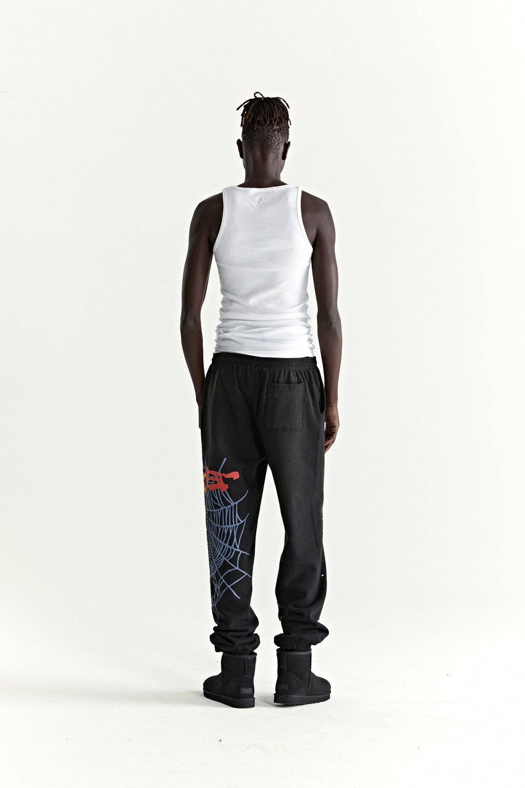 Black HEAVY WEB SWEATPANT with red SP5DER web graphic and scattered stars, worn by a person facing away.