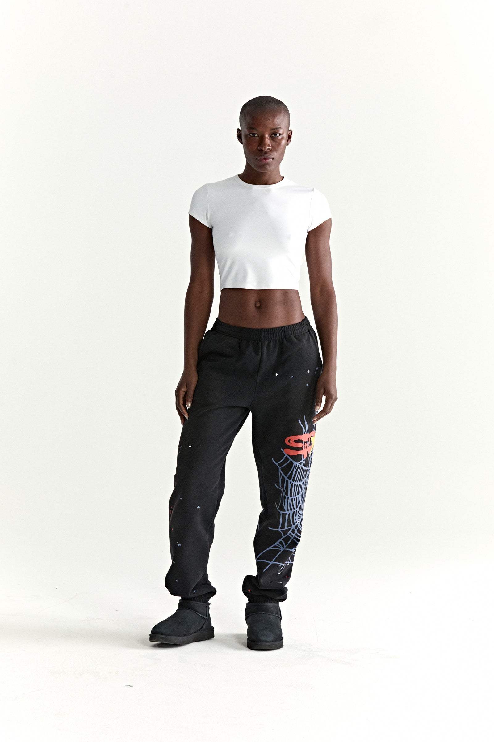 Black HEAVY WEB SWEATPANT with red SP5DER web graphic, scattered stars, and elasticized cuffs.