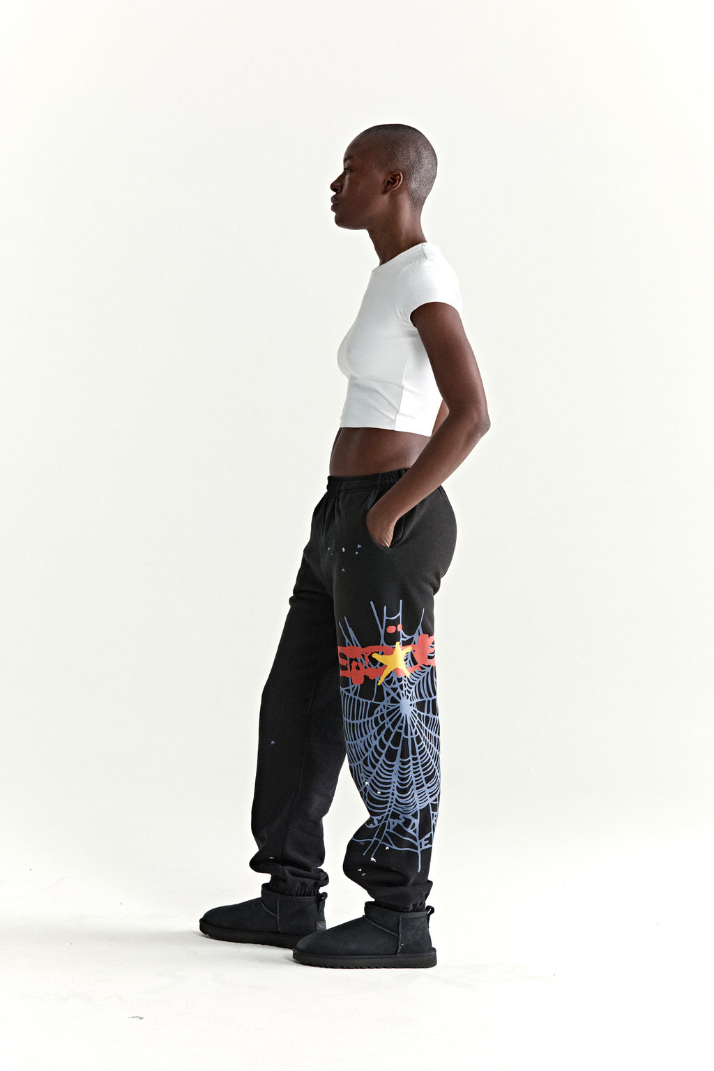 Black HEAVY WEB SWEATPANT with red SP5DER web graphic and scattered stars, worn by a model.