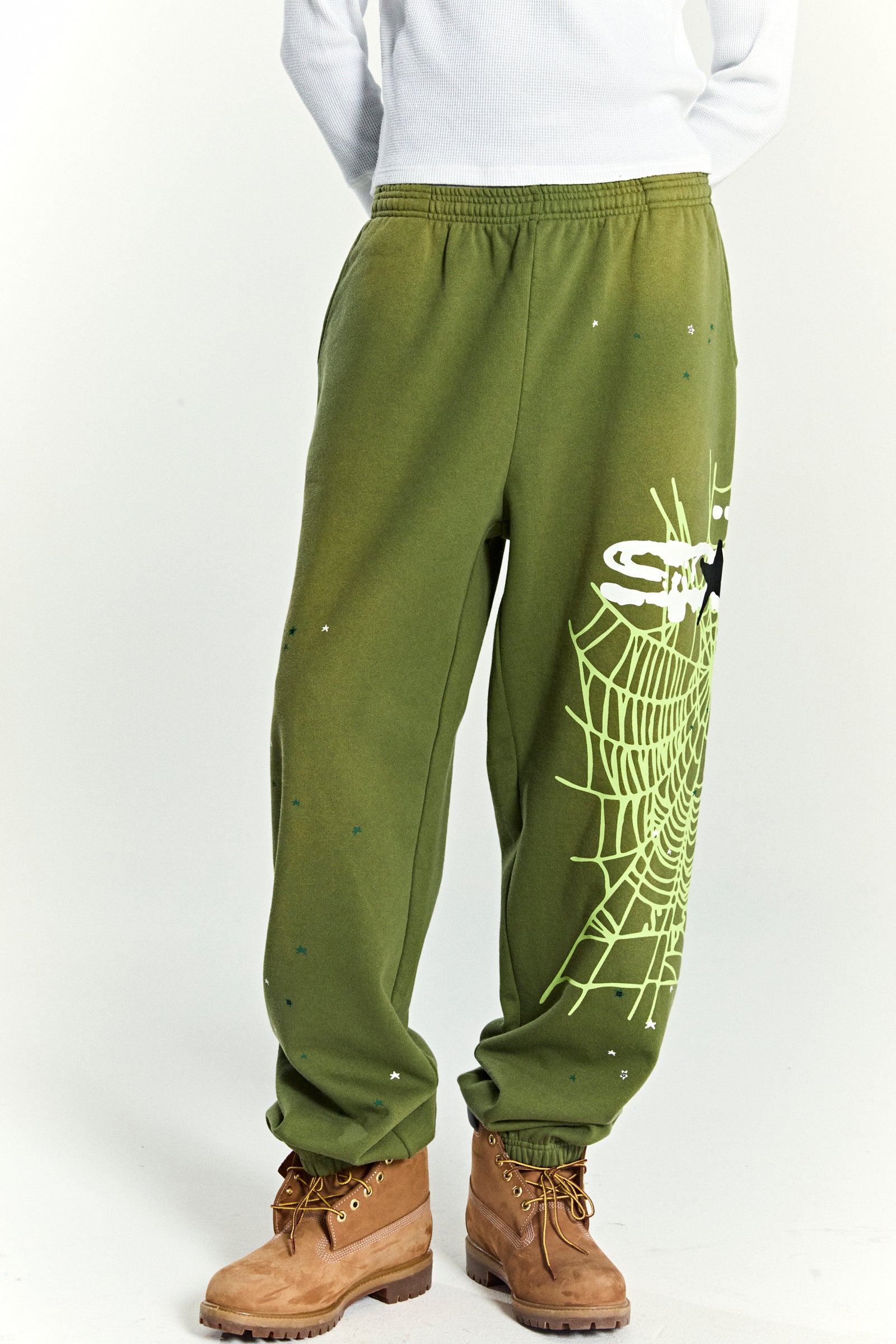 Olive green HEAVY WEB SWEATPANTS with a large SP5DER web graphic and scattered star print.