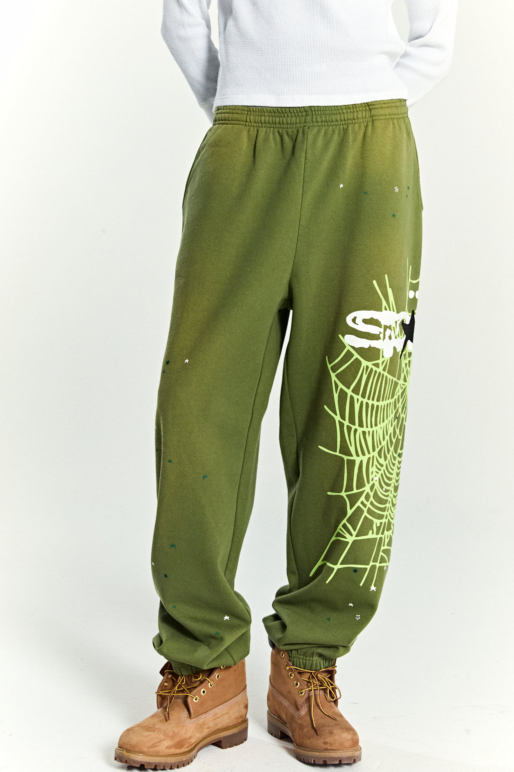 Olive green HEAVY WEB SWEATPANTS with a large SP5DER web graphic and scattered star print.