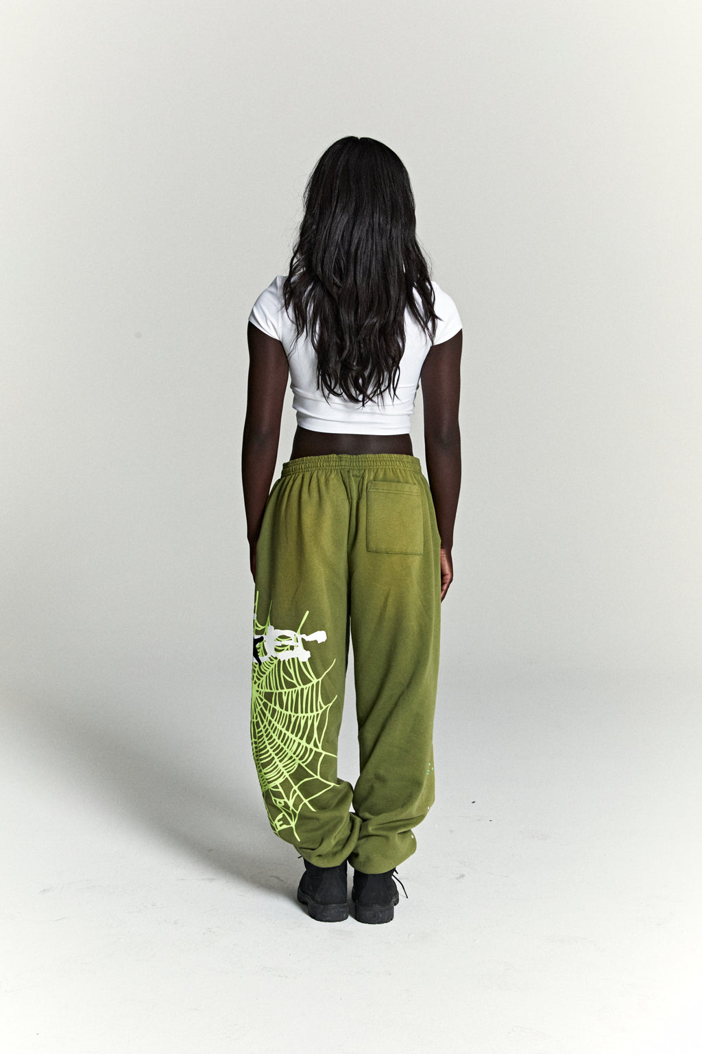 Olive green HEAVY WEB SWEATPANT with neon green SP5DER web graphic and scattered stars.