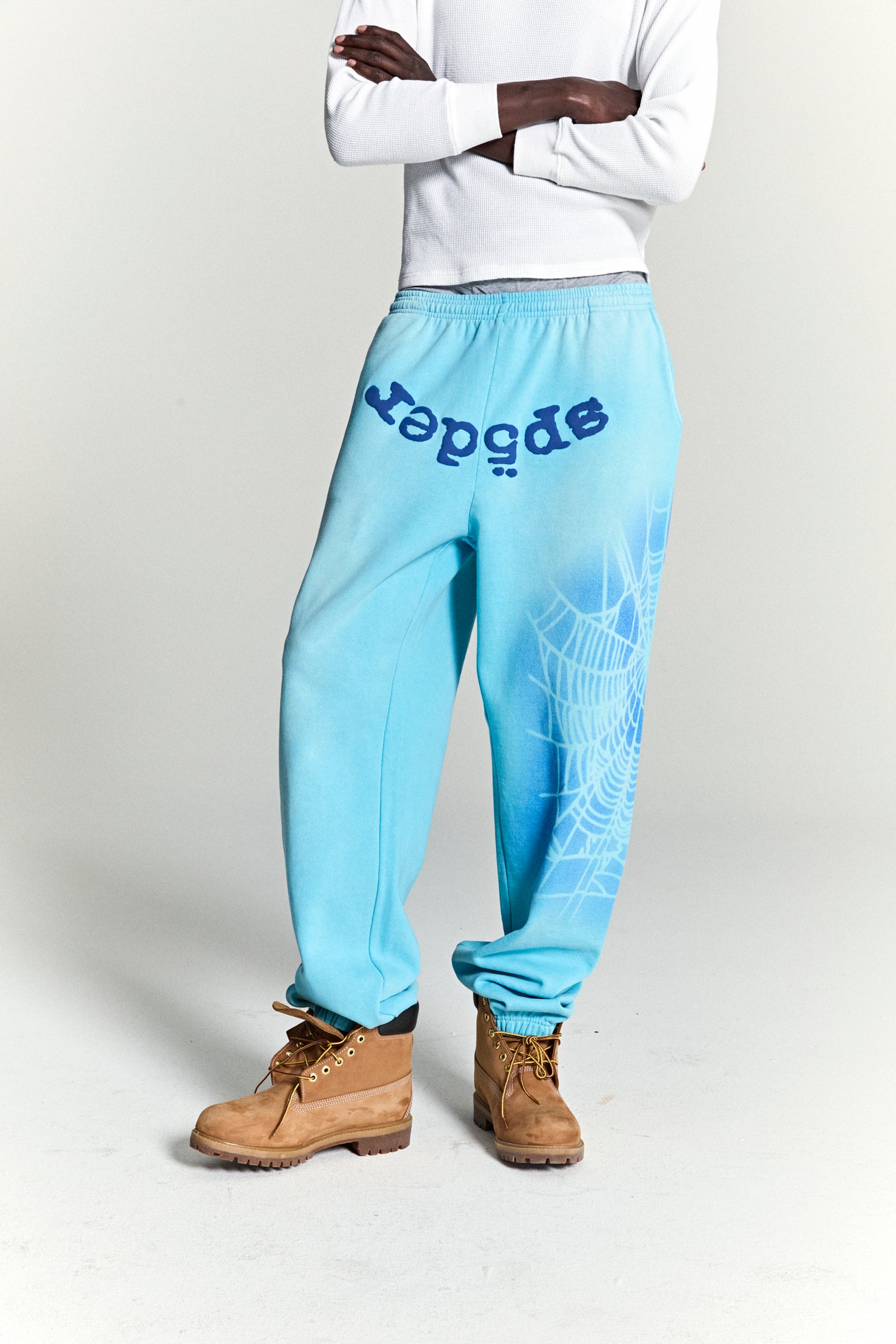 Light blue cotton fleece sweatpants with "SP5DER" text and spray web design.