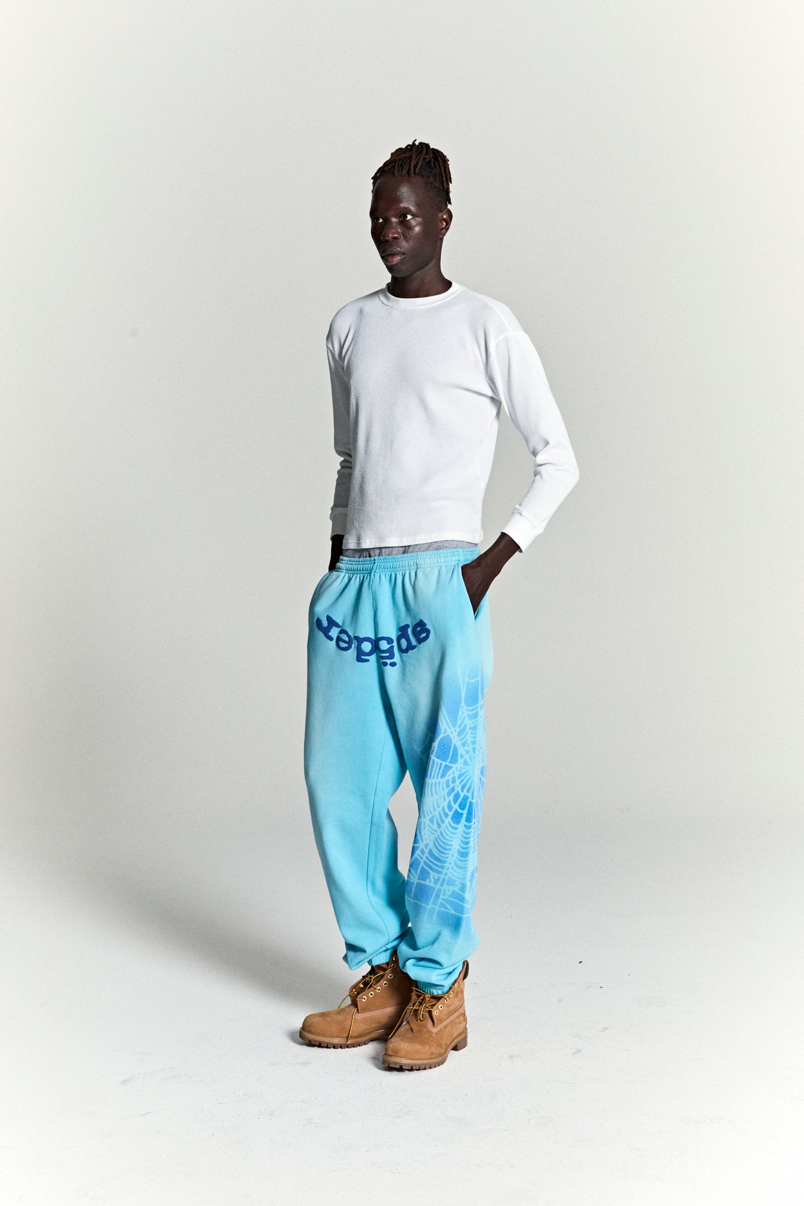 Light blue OG WEB V2 SPRAY SWEATPANT with "SP5DER" text and white spray web design.