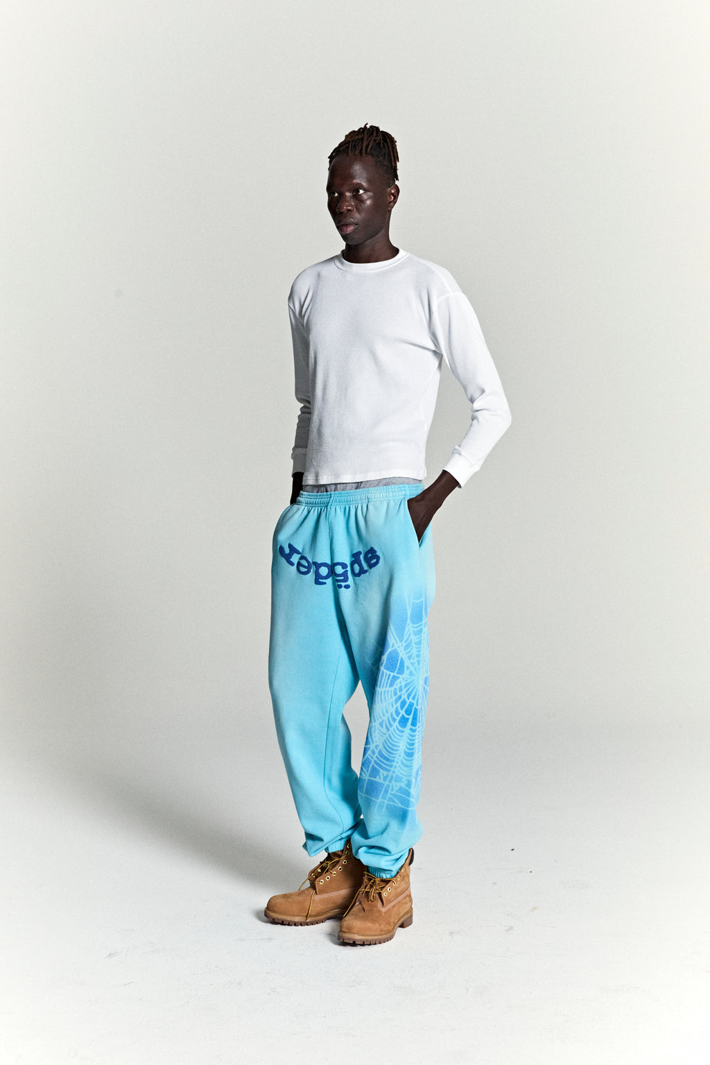 Light blue OG WEB V2 SPRAY SWEATPANT with "SP5DER" text and white spray web design.