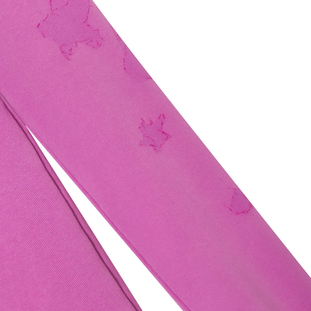 Pink cotton fleece sweatpants featuring distressed star graphic designs and a soft, textured finish.