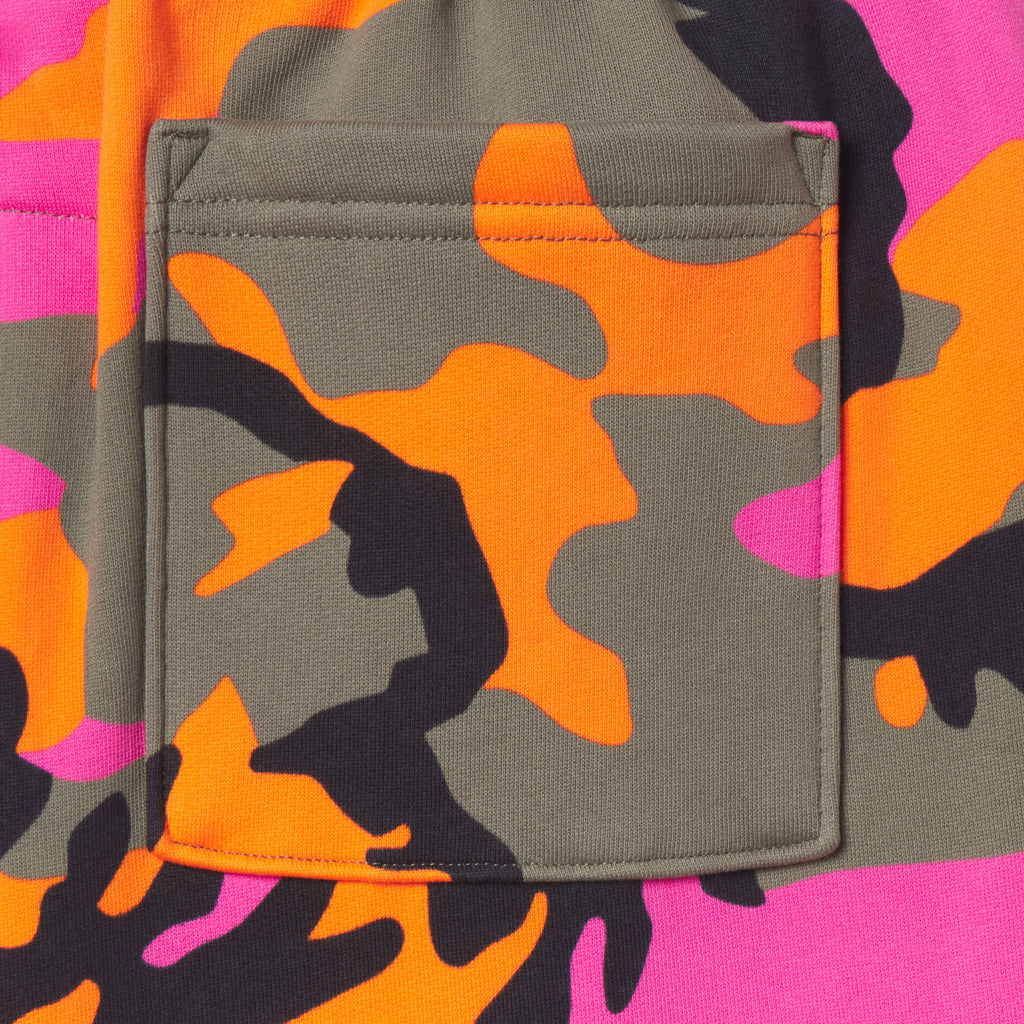 Close-up of 100% cotton fleece sweatpants featuring a vibrant pink, orange, and olive green camo graphic print and pocket.