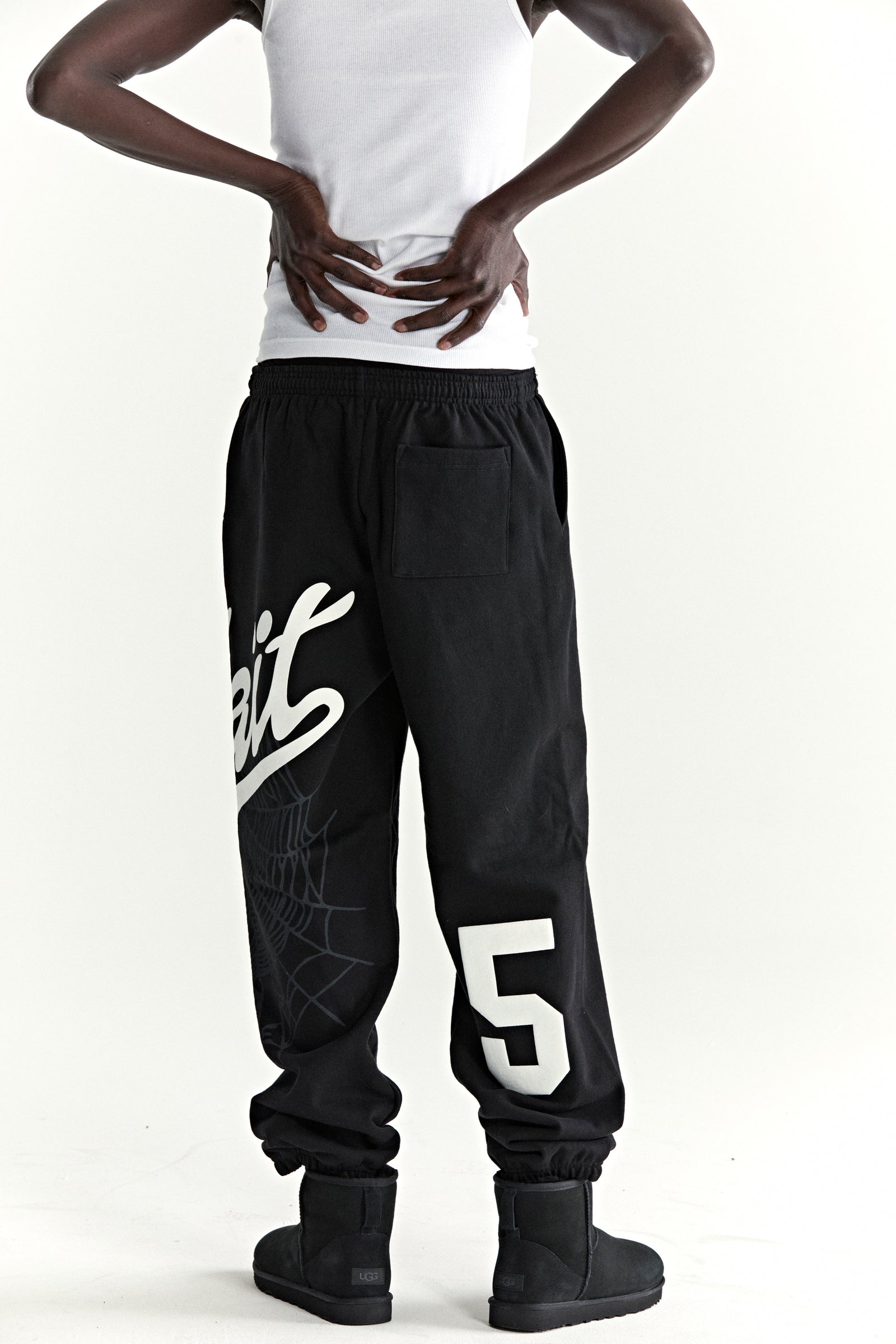 Black cotton fleece sweatpants with "Wait" script, spiderweb, and "5" motifs.