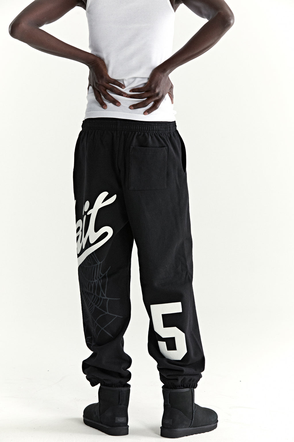 Black cotton fleece sweatpants with "Wait" script, spiderweb, and "5" motifs.