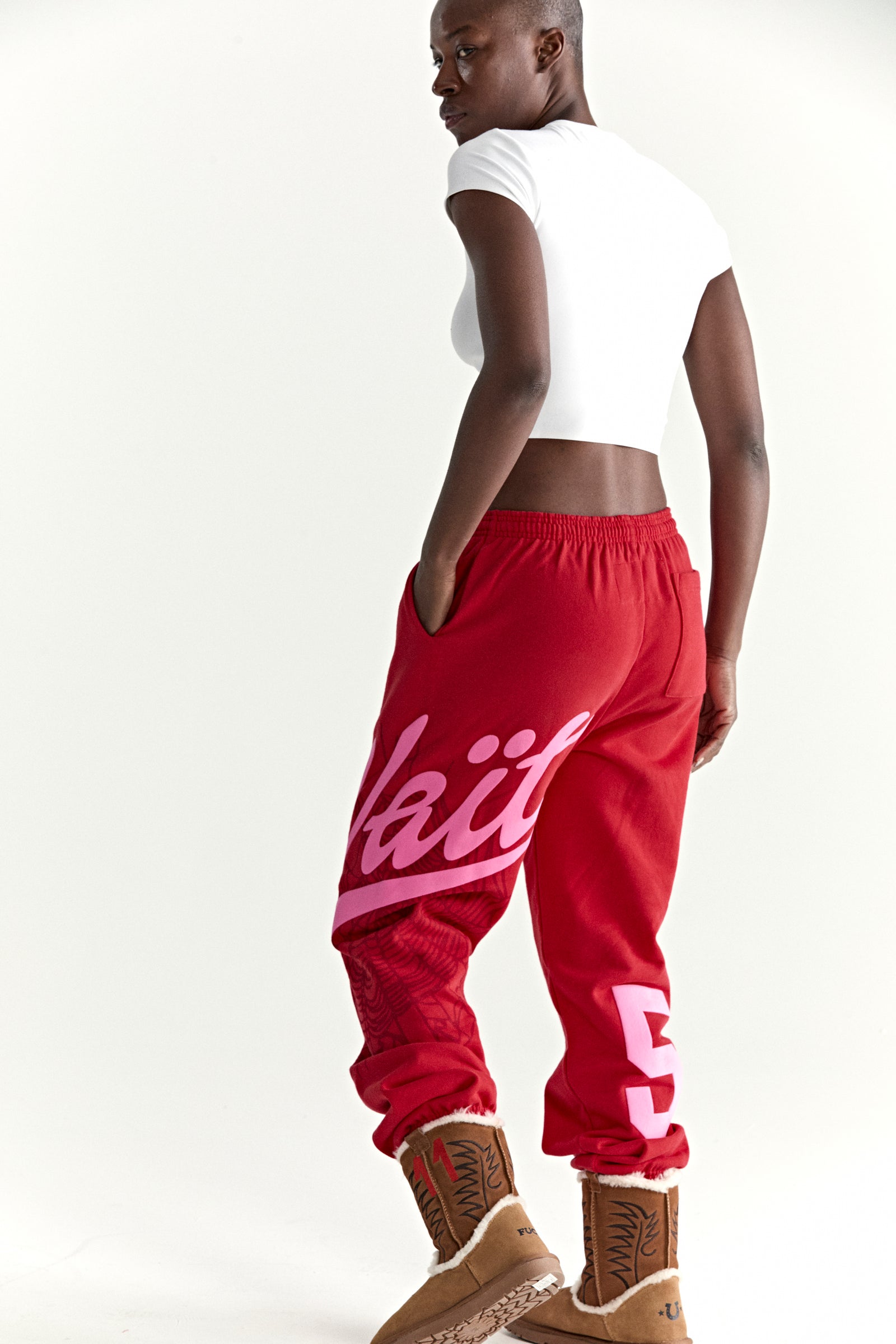 Red cotton fleece sweatpants with pink "Wait" script, web print, and "5" motif.