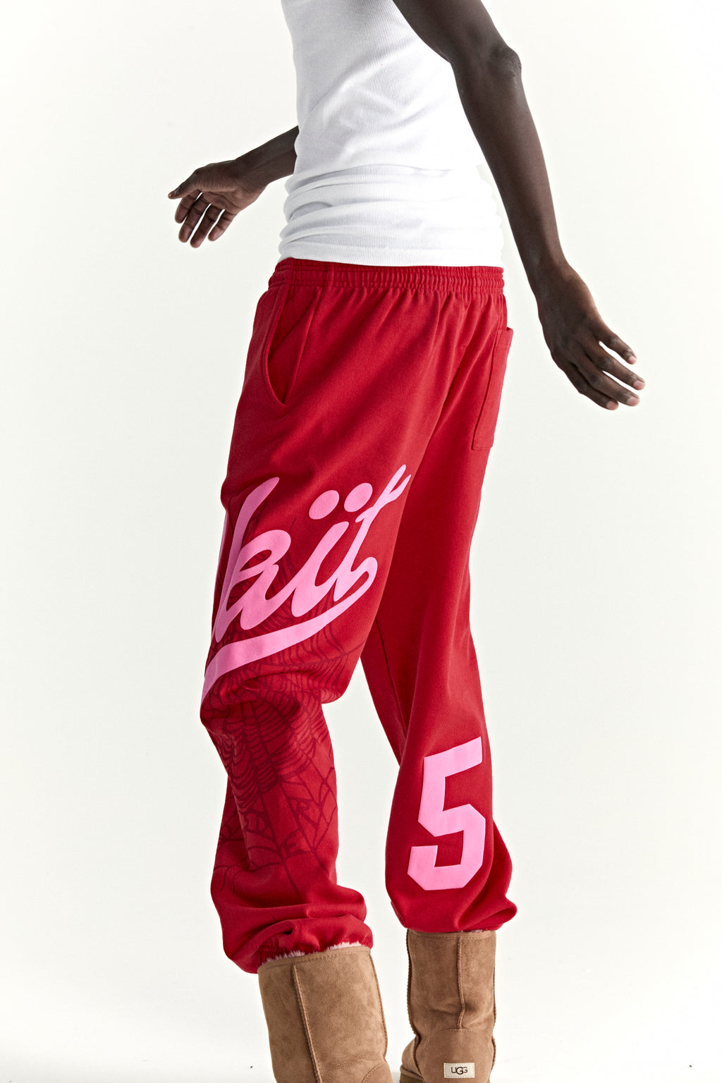 Red cotton fleece sweatpants with pink "Wait" script, web print, and "5" motif.