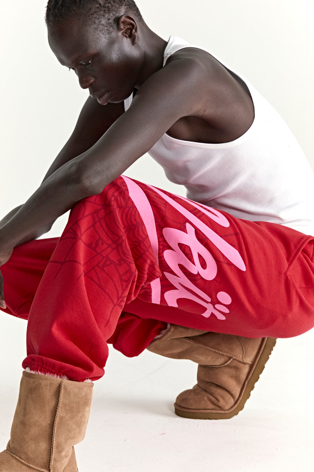 Red cotton fleece STADIUM SWEATPANT with pink 'Wait' script and web print, elasticized cuffs.