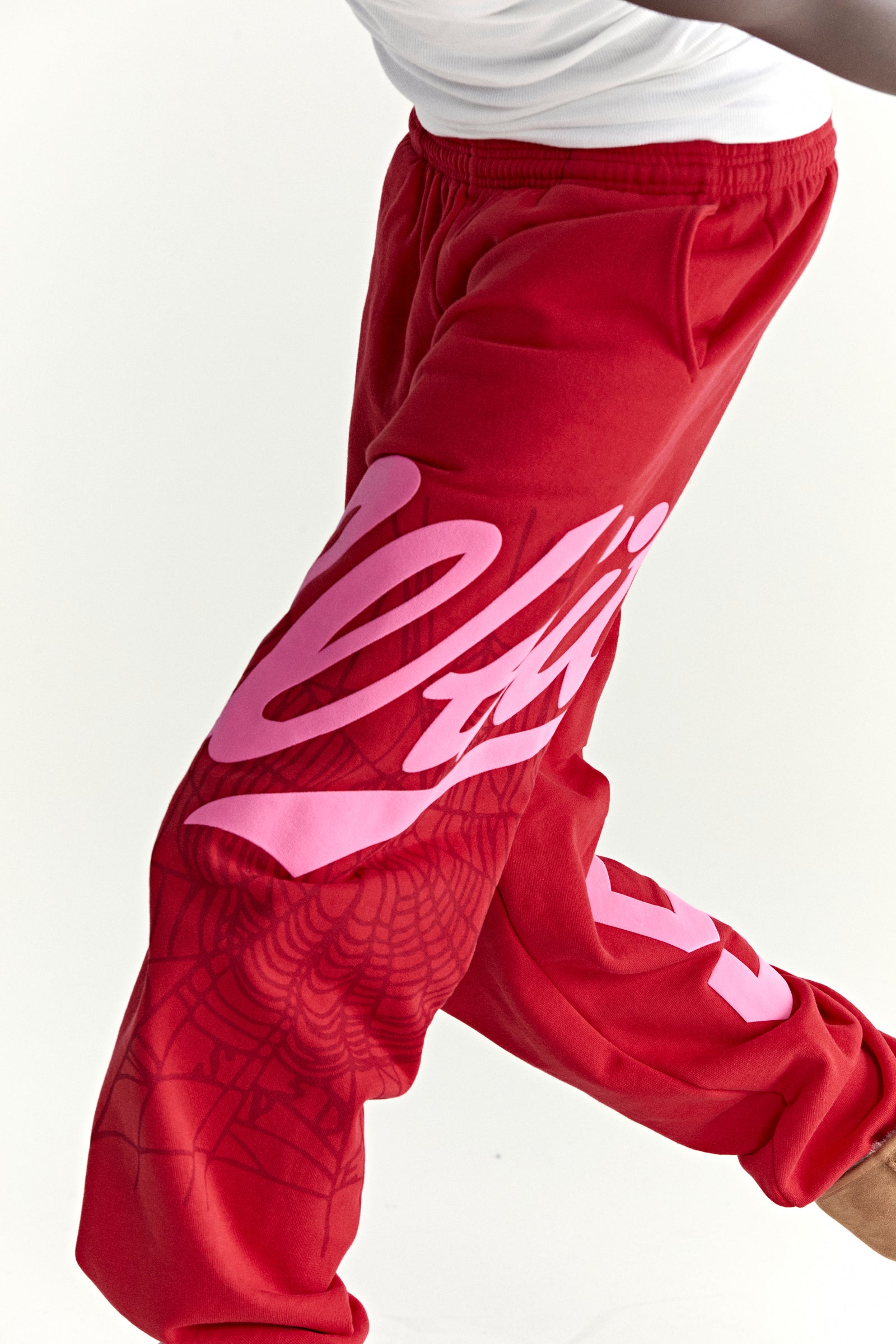 Red cotton fleece sweatpants with pink "Wait" script, web print, and "5" motif.