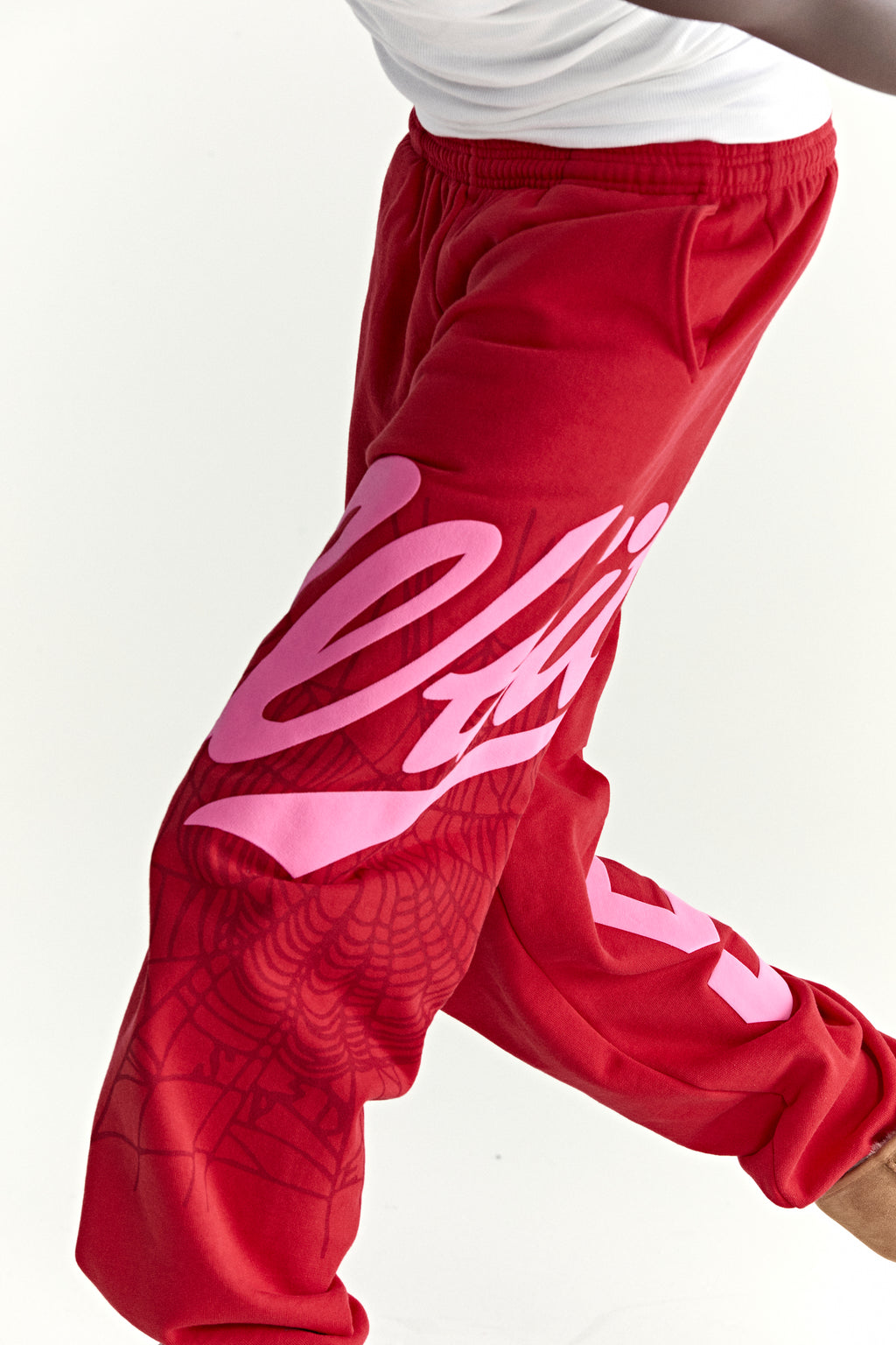 Red cotton fleece sweatpants with pink "Wait" script, web print, and "5" motif.