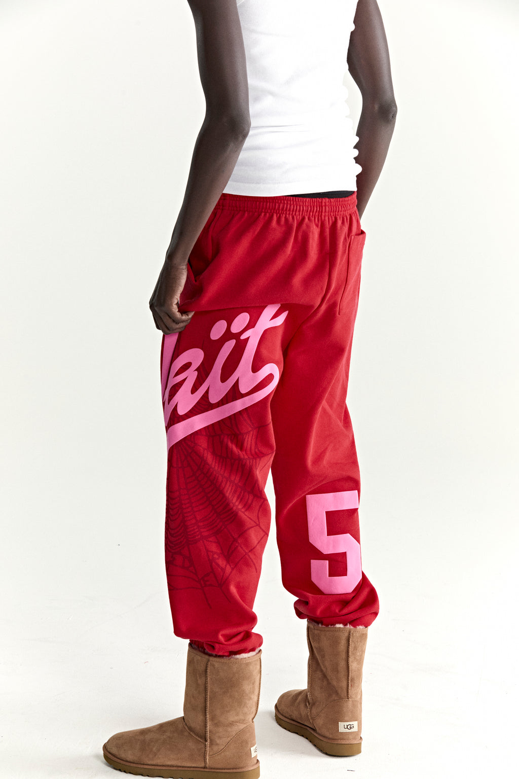 Red cotton fleece sweatpants with pink "Wait" script, spiderweb, and "5" prints.