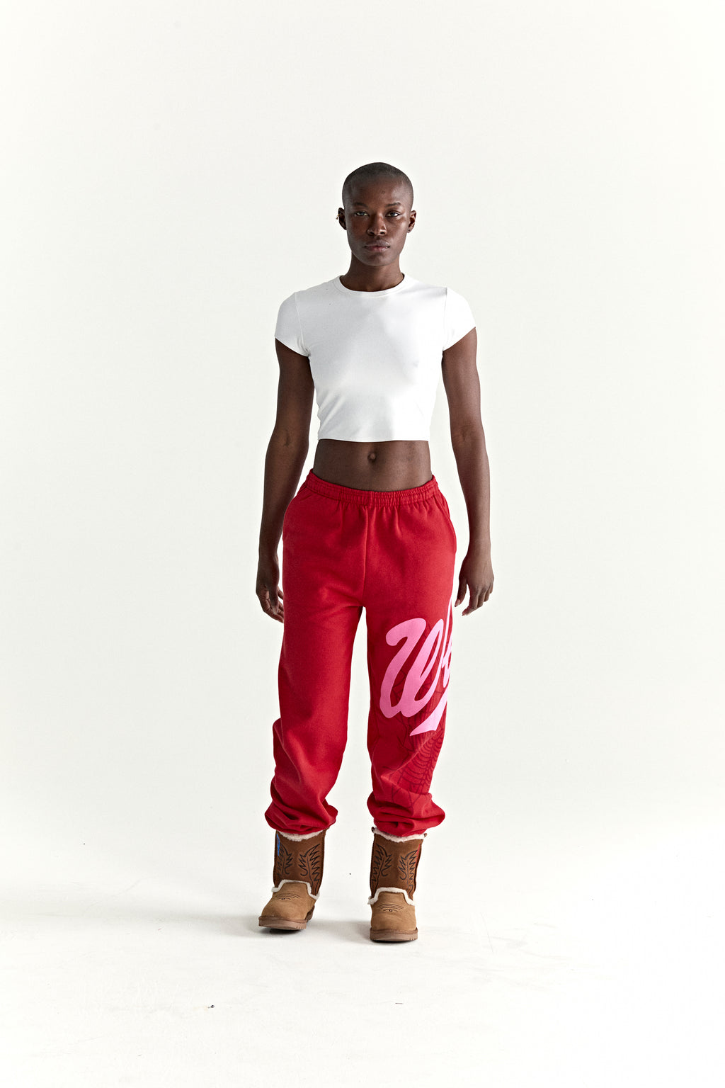 Red cotton fleece sweatpants with pink 'Wait' script and web print, elasticized cuffs.