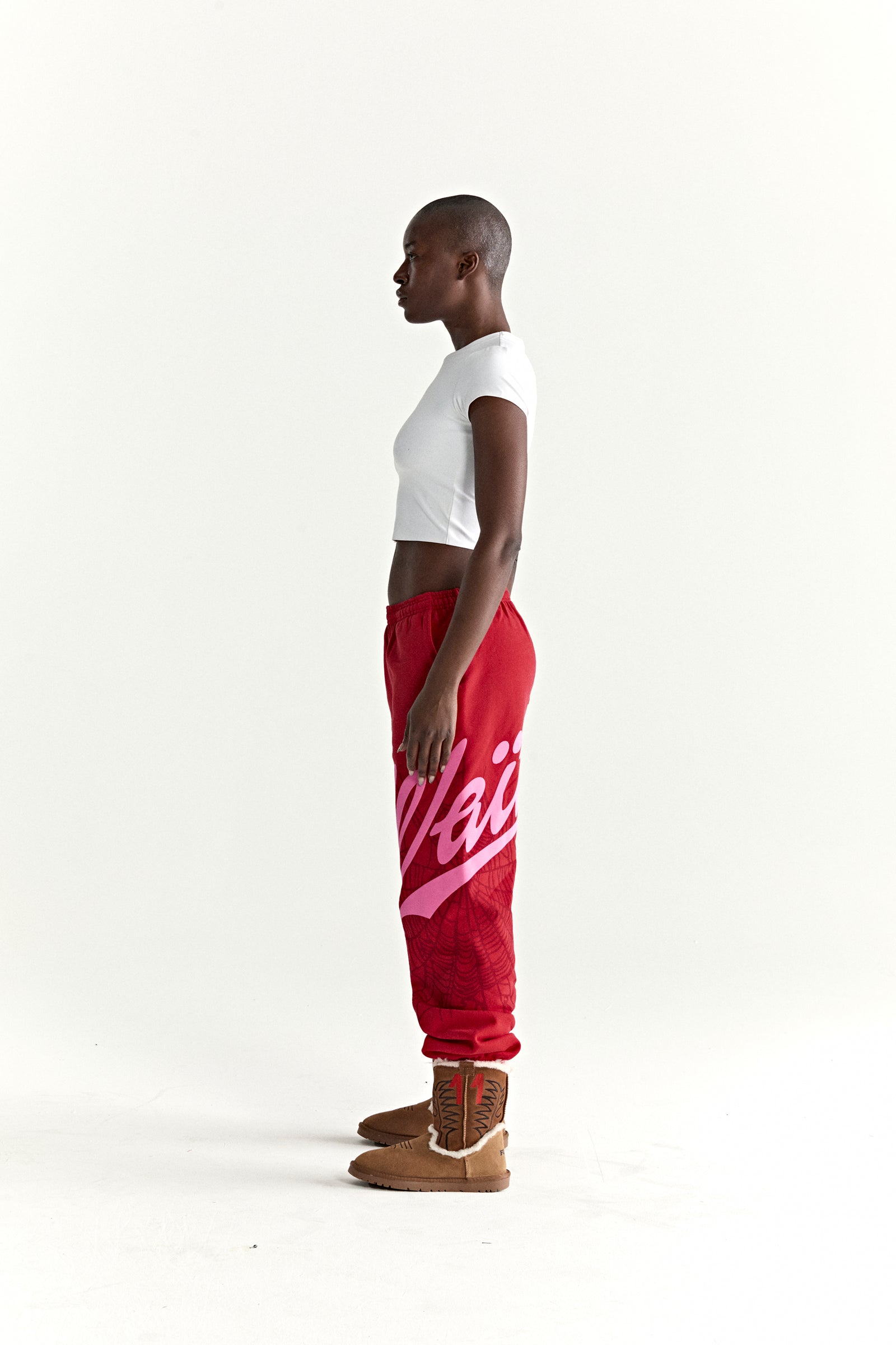 Red cotton fleece sweatpants with "Wait" script and web print, elasticized cuffs and waistband.