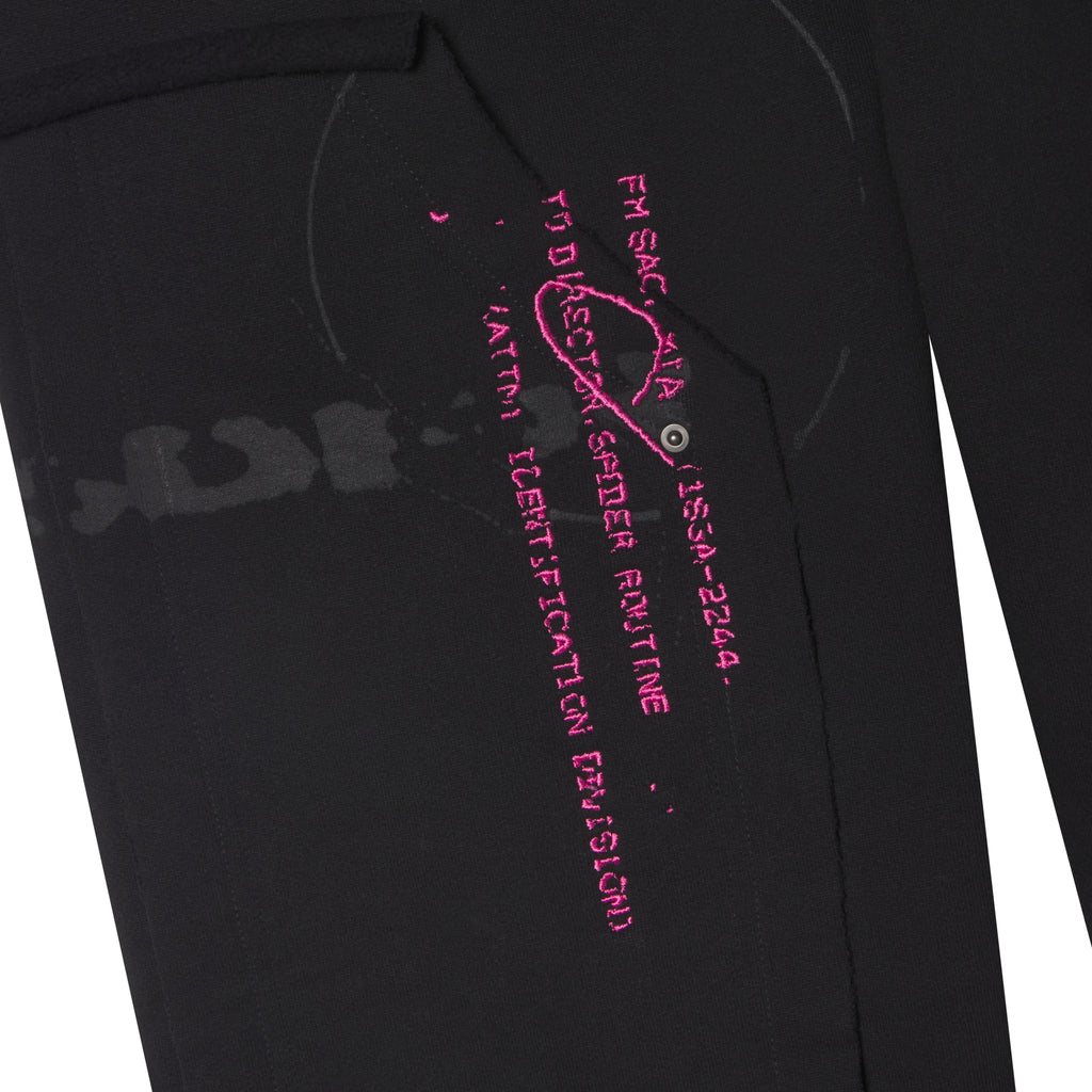 Black 100% cotton fleece sweatpants featuring pink embroidered graphic text and distressed abstract prints on a wide leg.