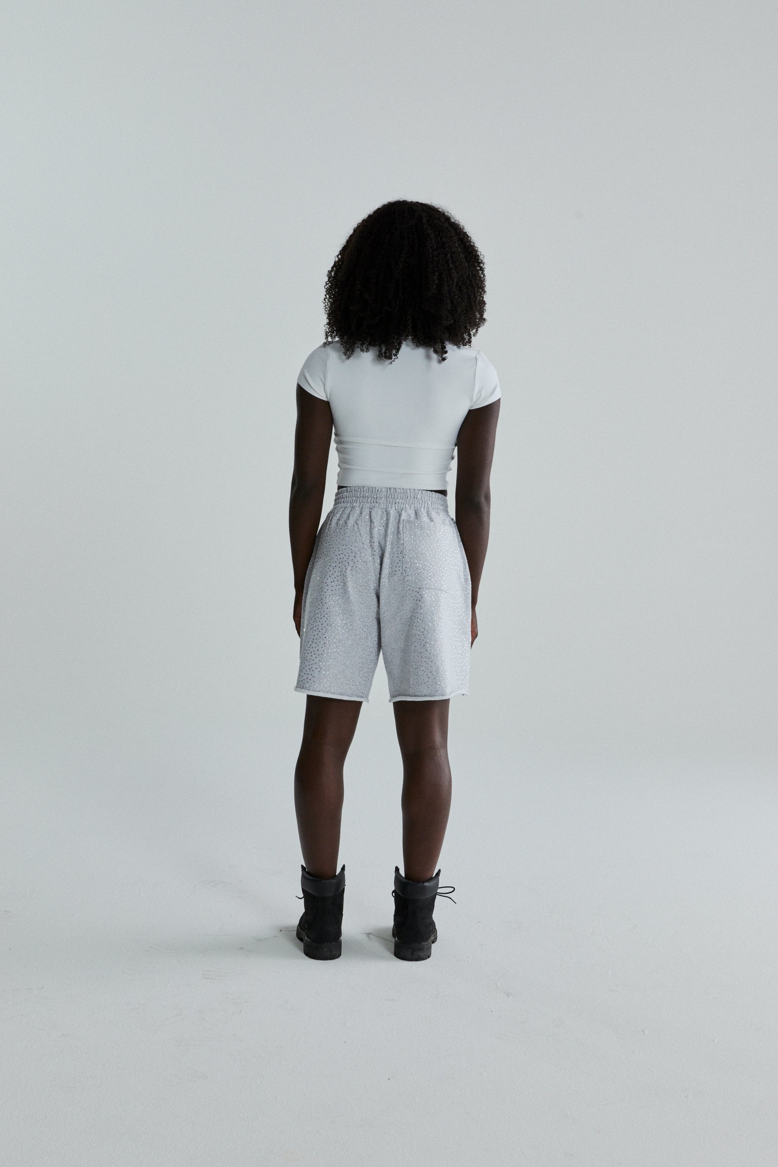 Woman wearing VVS SWEATSHORT: light grey cotton fleece shorts with tonal rhinestone application and raw hem.