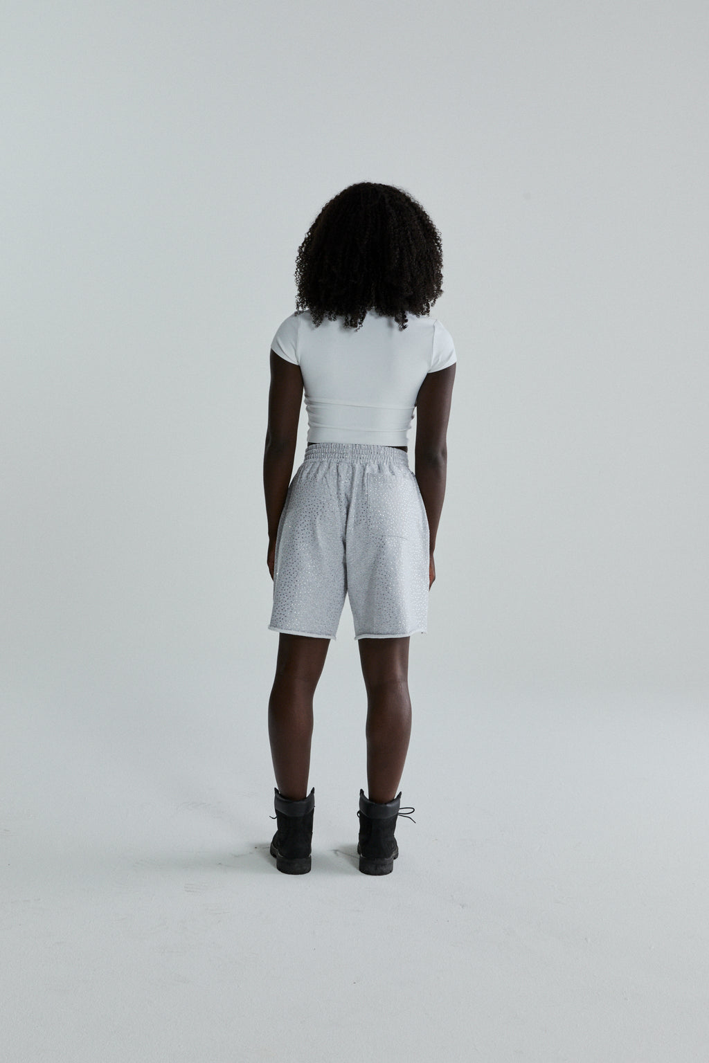 Woman wearing VVS SWEATSHORT: light grey cotton fleece shorts with tonal rhinestone application and raw hem.