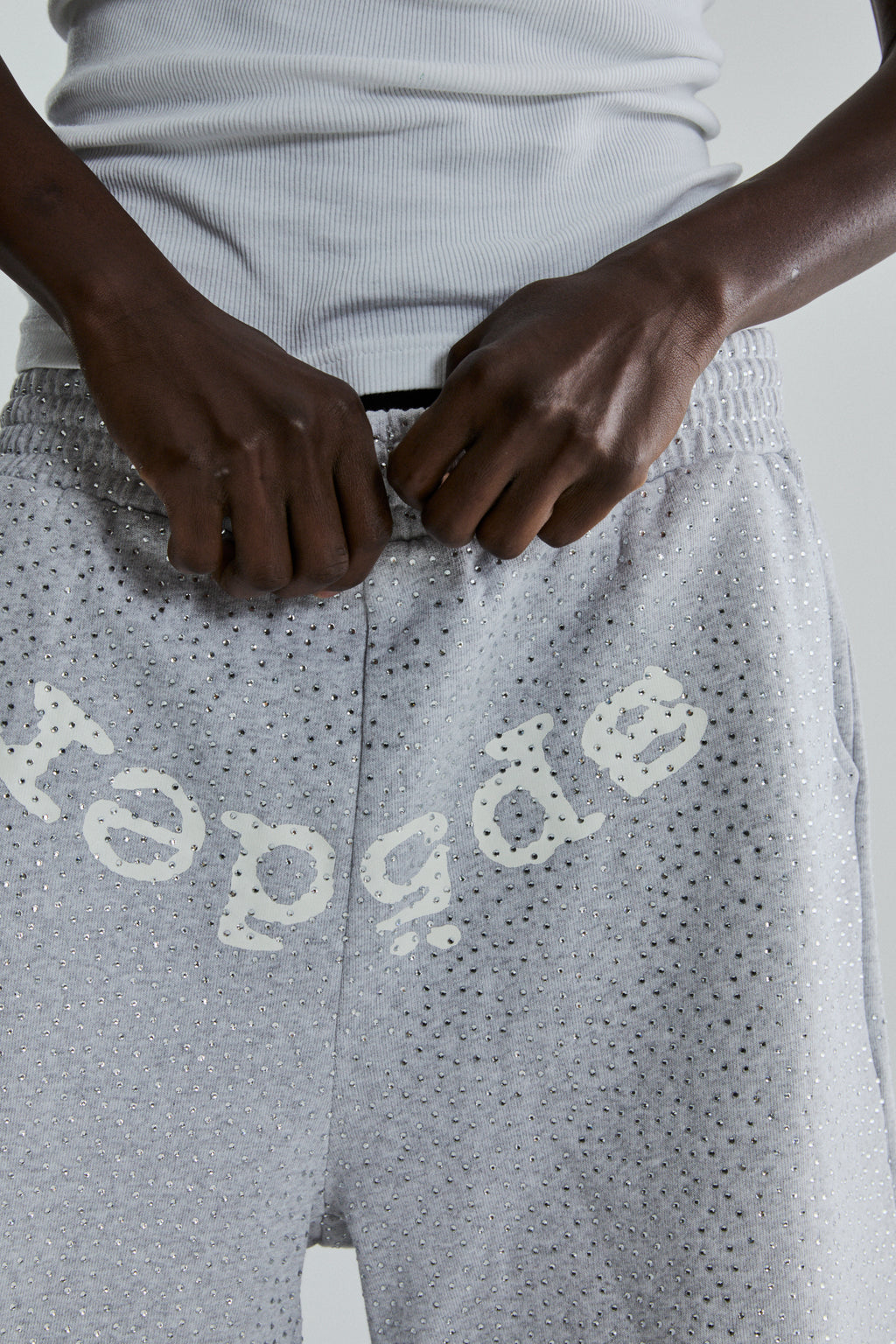 Light grey VVS sweatshorts with all-over tonal rhinestones and "SP5DER" text across the crotch.