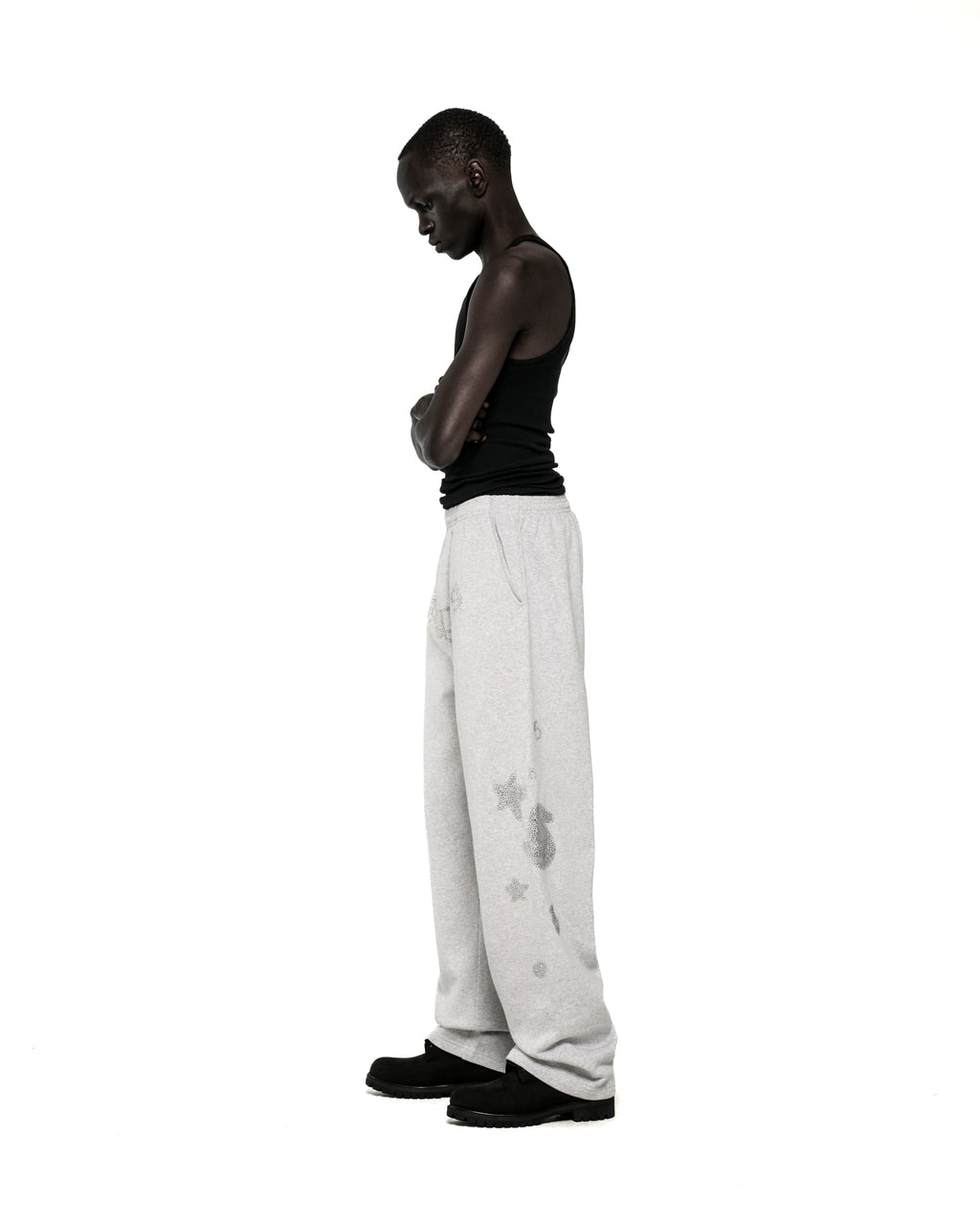 Light grey wide-leg sweatpants with rhinestone 'SP5DER' text, '5', and star designs.