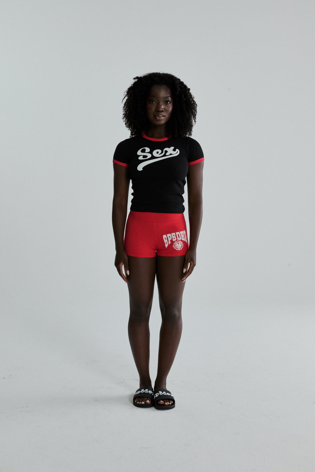 Black cropped cotton/spandex tee with "Sex" graphic, red ribbed trim.