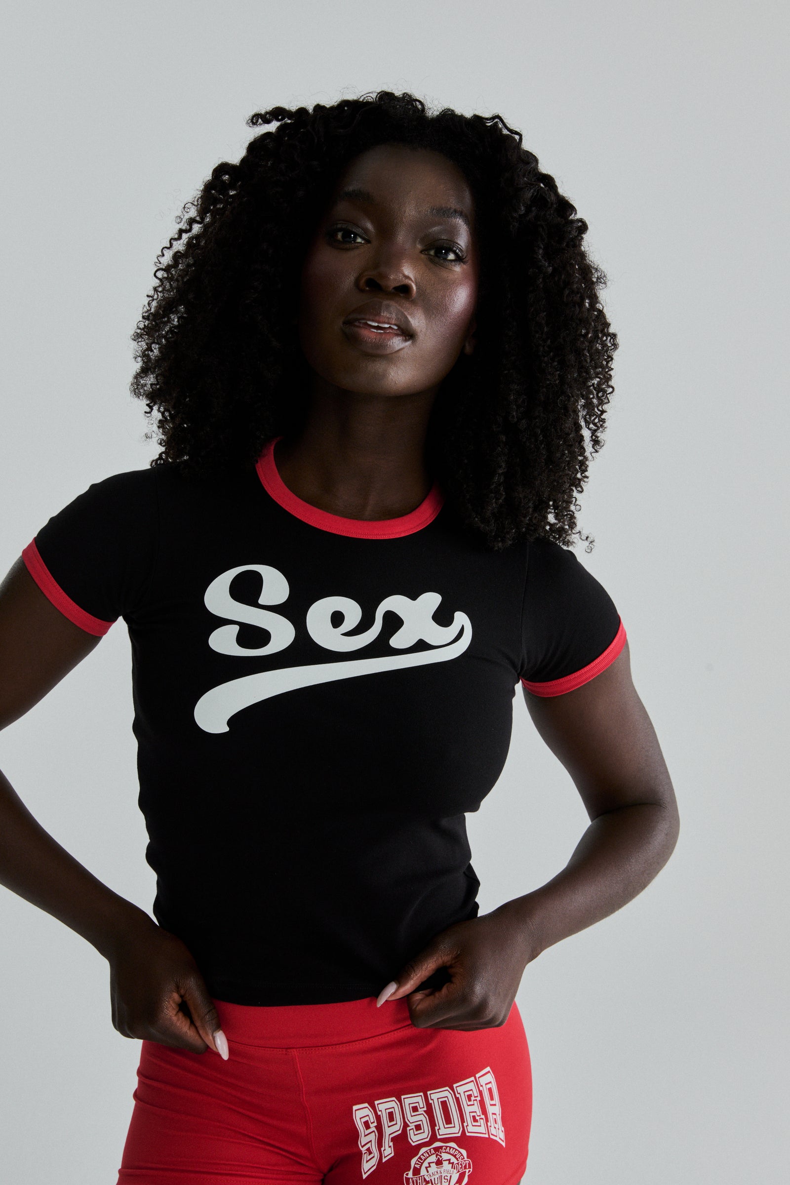 Black cropped cotton/spandex tee with "Sex" graphic, red ribbed trim, worn by a model.