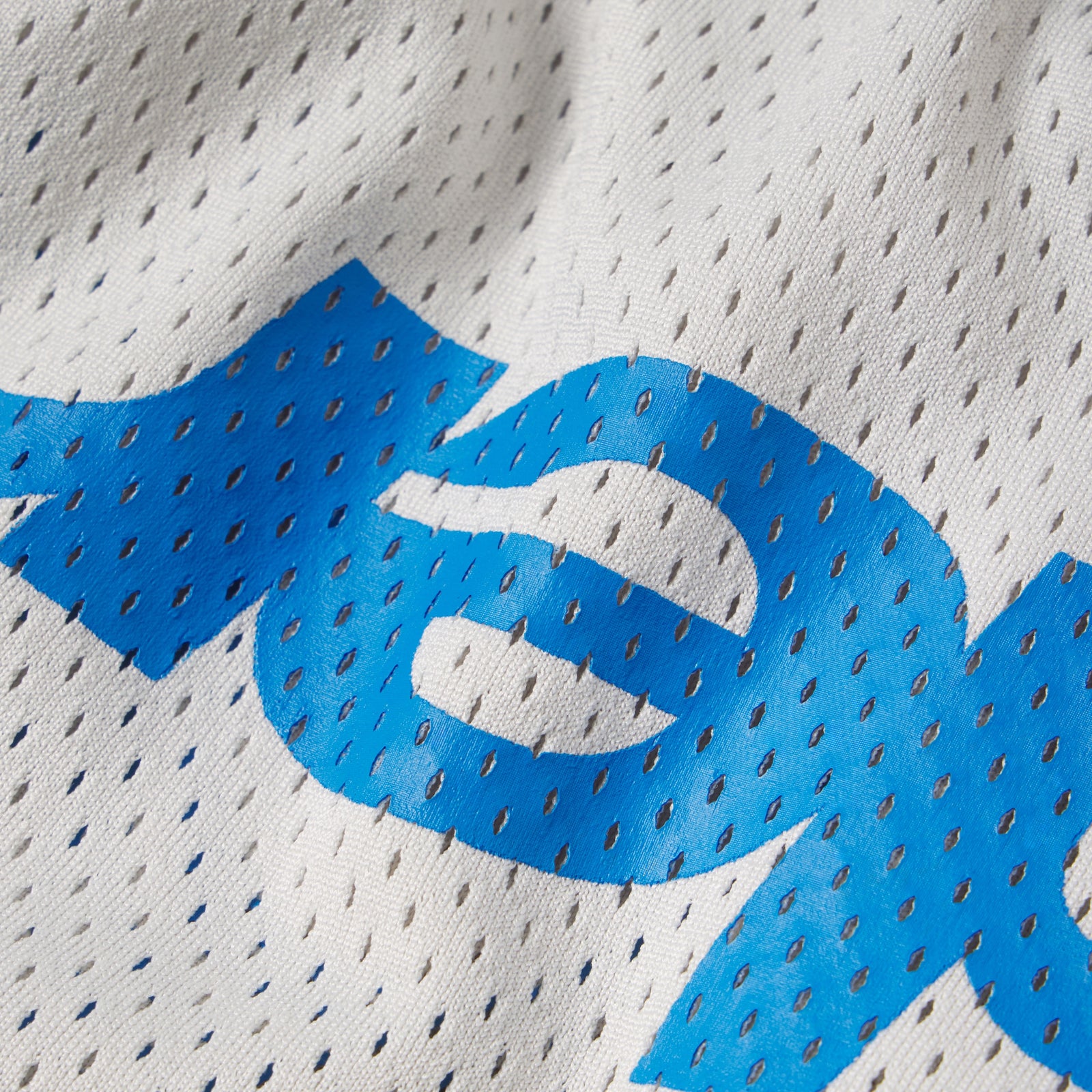 White breathable mesh fabric with bold blue graphic print design.
