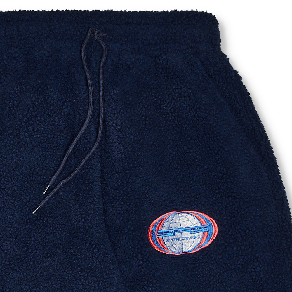 Navy sherpa wide leg pant with drawstring waist and "Worldwide" globe patch.
