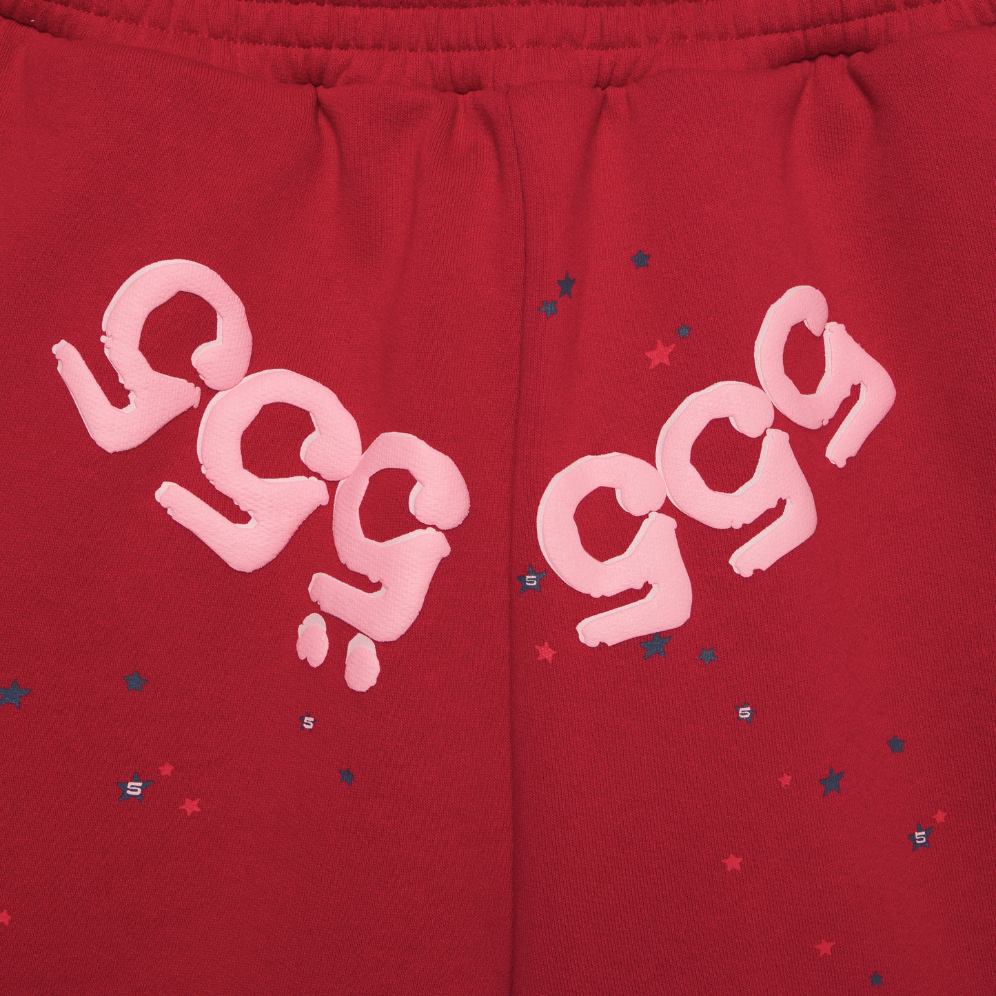 Red 13oz cotton fleece shorts with pink "999" angel number print and scattered stars.