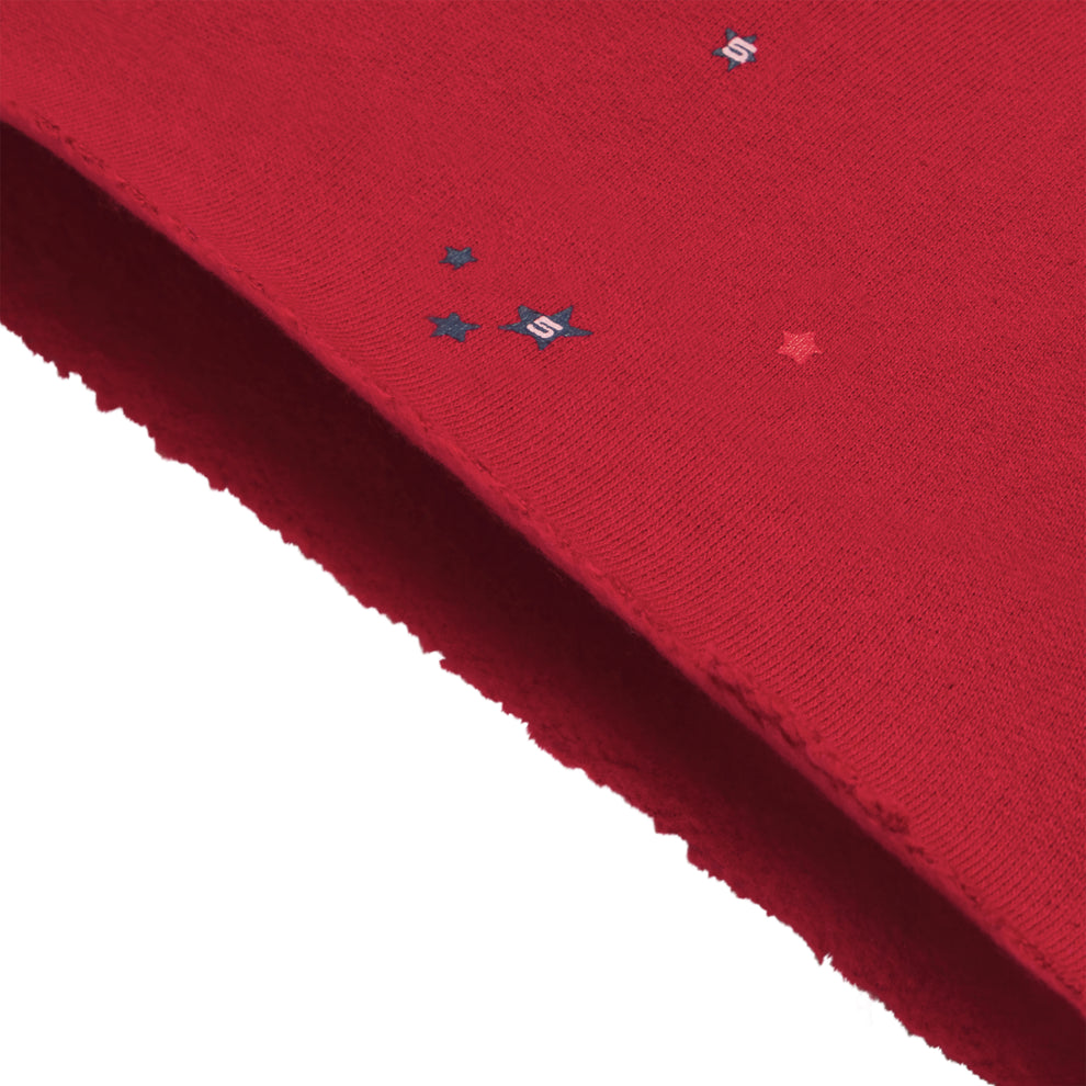 Red 13oz cotton brushed fleece shorts with scattered star print and raw hem.