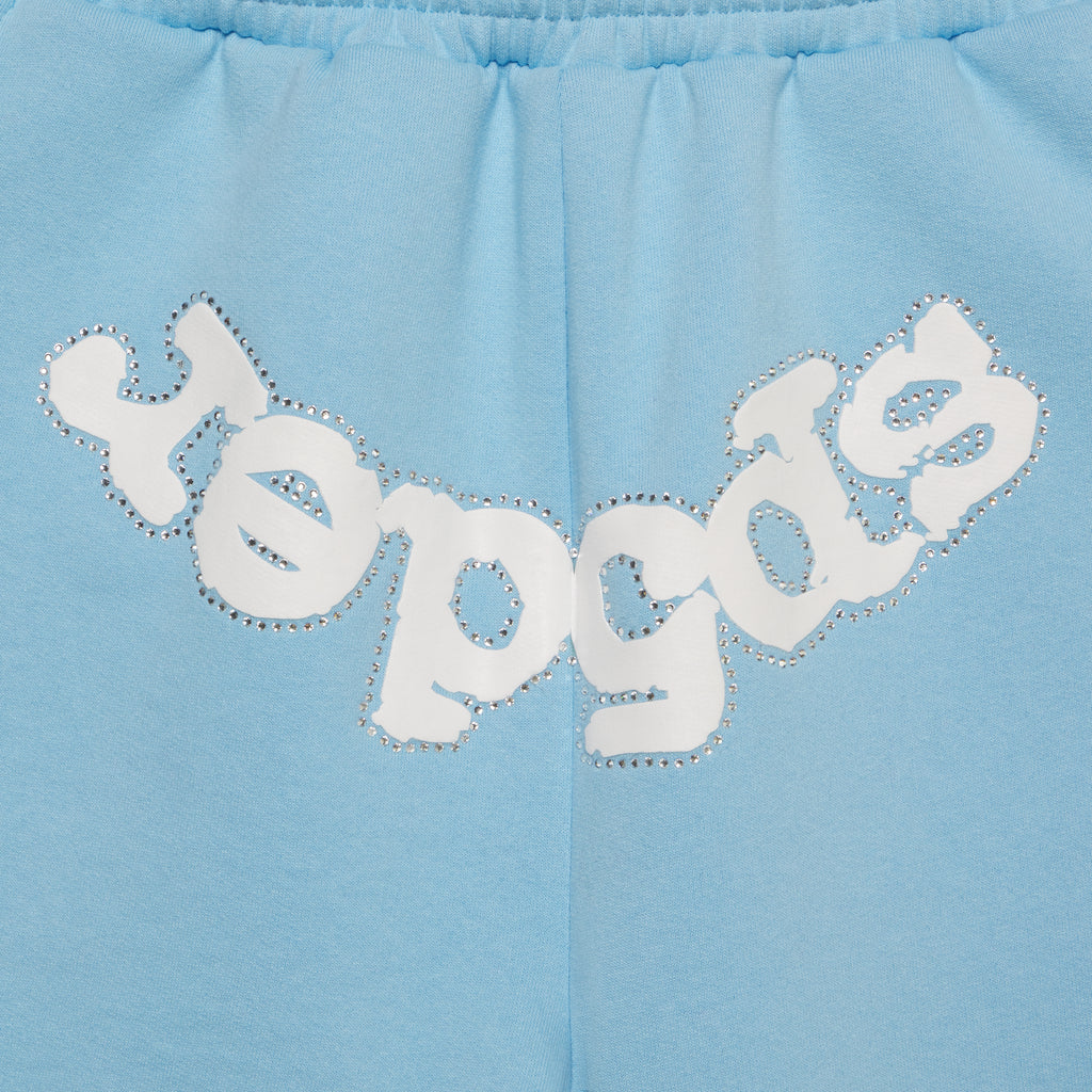 Light blue cotton fleece sweatshorts with "SP5DER" text in white and silver rhinestones on the crotch.
