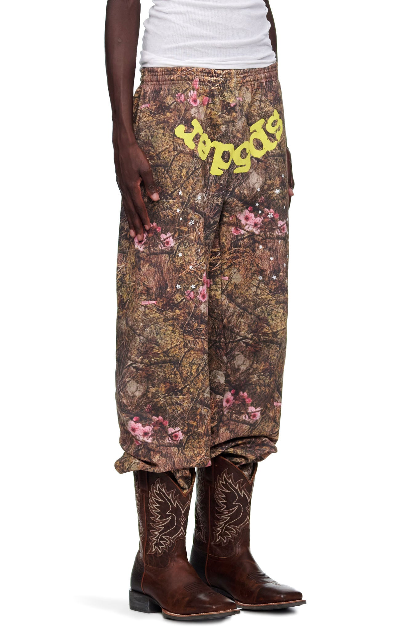 REAL TREE OG WEB SWEATPANT: Camo fleece sweatpants with pink flowers and yellow "SP5DER" puff print text.