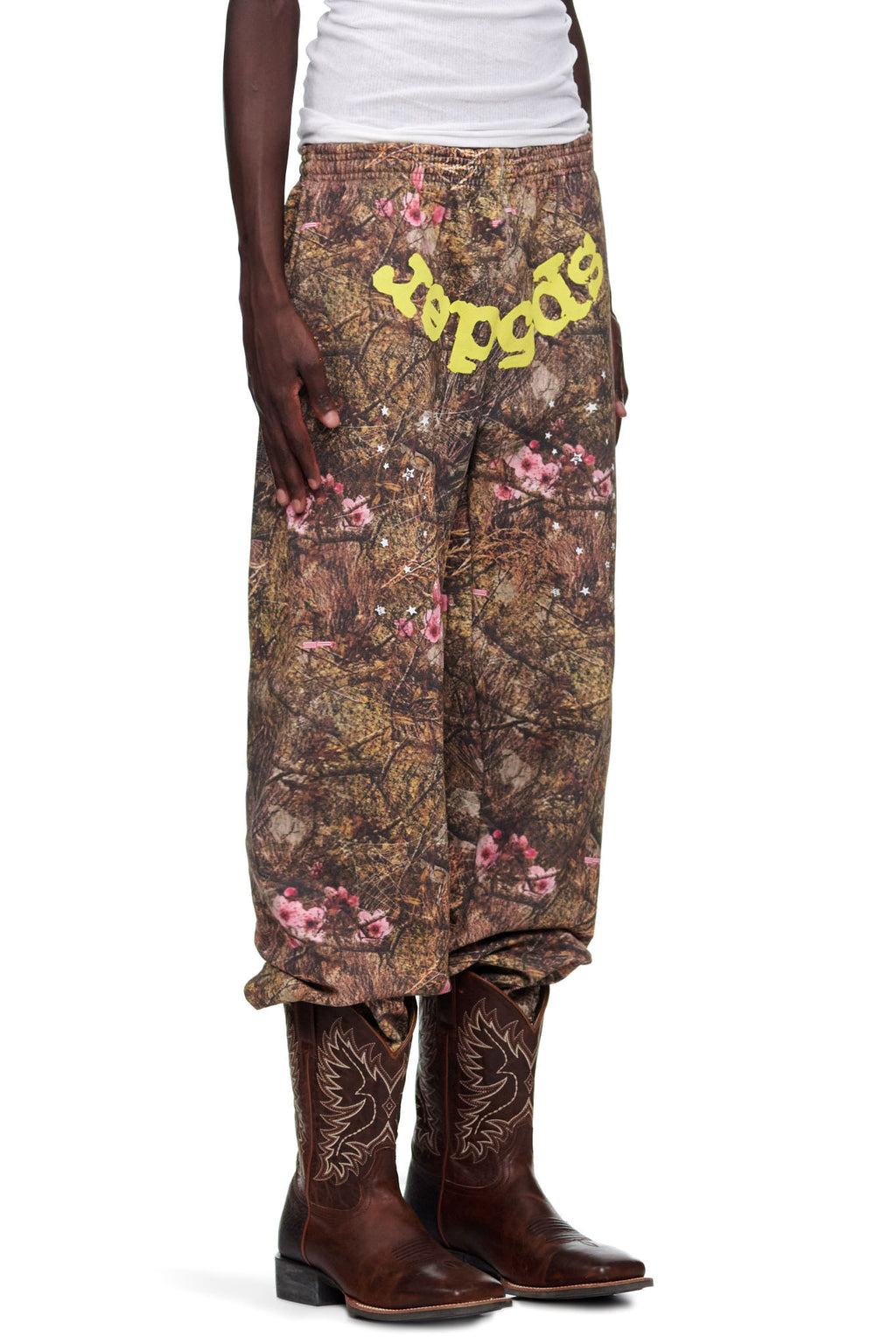 REAL TREE OG WEB SWEATPANT: Camo fleece sweatpants with pink flowers and yellow "SP5DER" puff print text.
