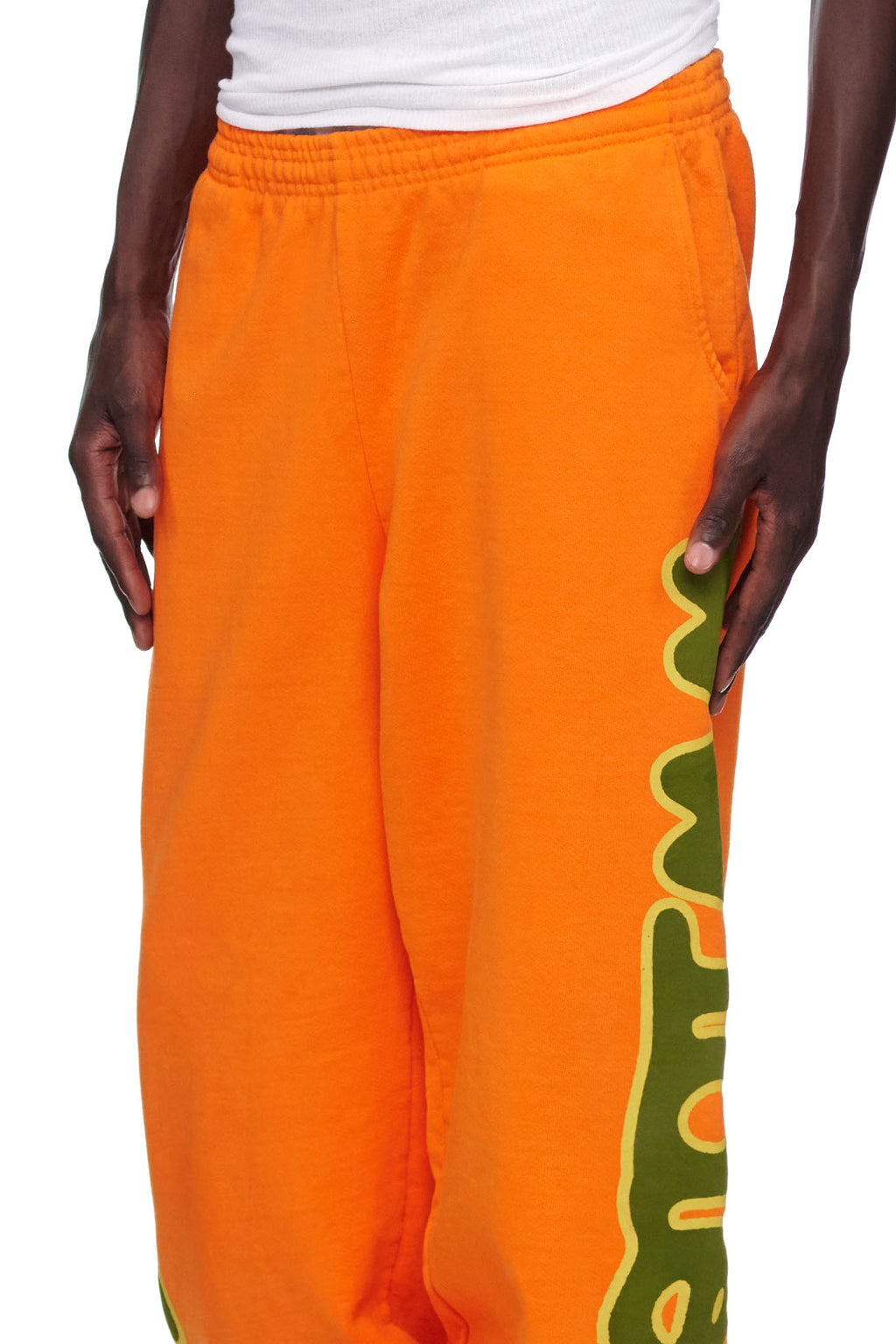 Orange BELUGA SWEATPANT with green 'Worldwide' puff print down the leg.