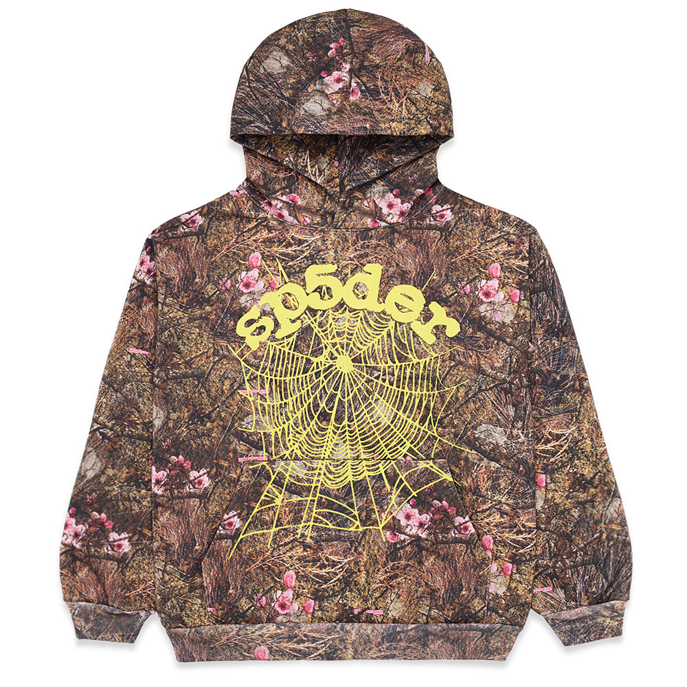 REAL TREE OG WEB HOODIE: Brown camo fleece hoodie with pink flowers, yellow "SP5DER" text, and a spider web graphic.