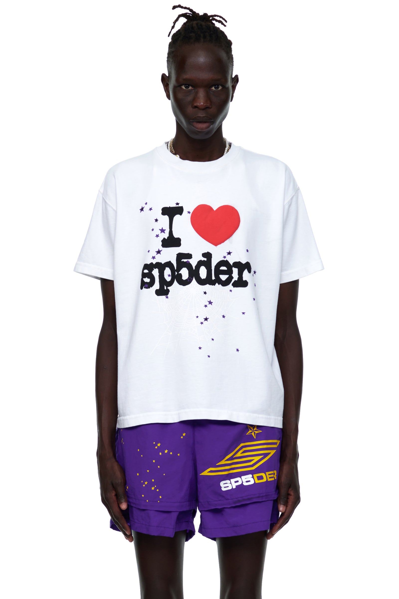 White cotton I HEART SP5DER men's tee with red heart graphic and purple shorts.