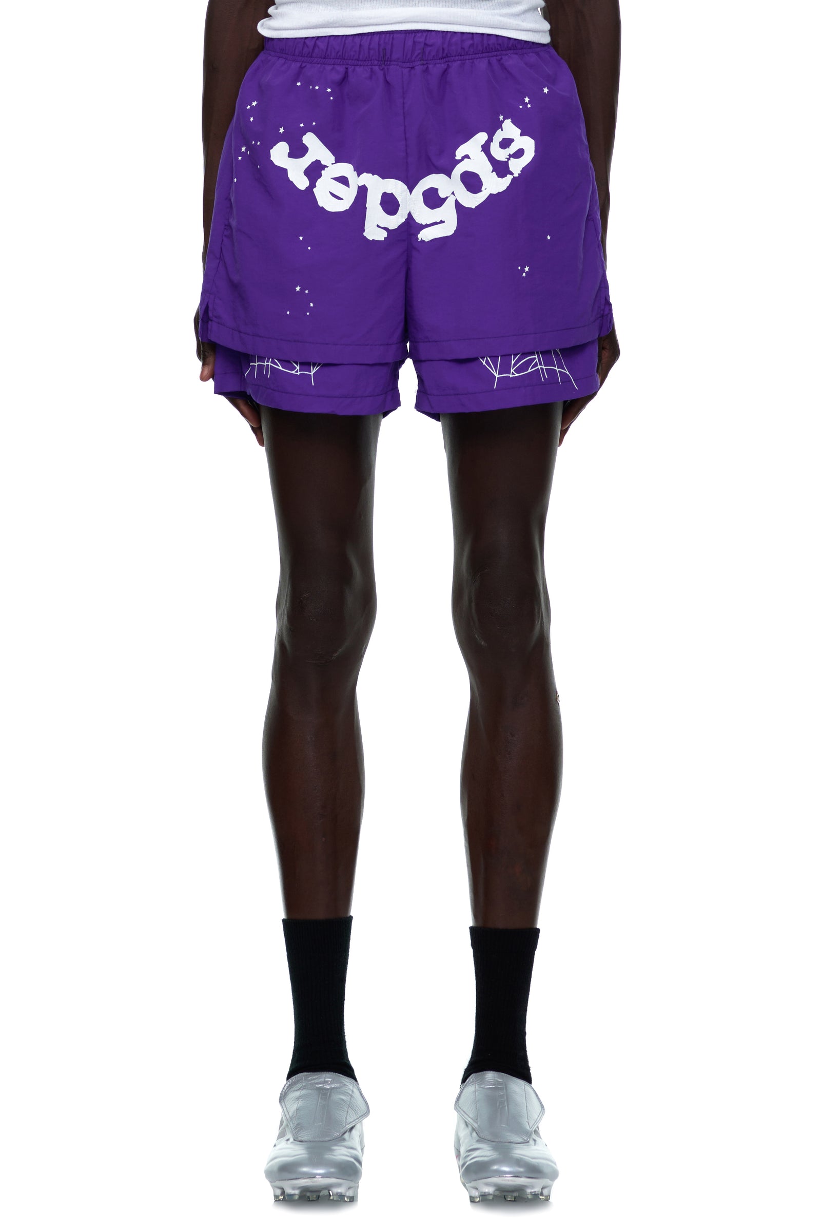 Purple nylon shorts with white "sp5der" text, web print, and paint splatter design.