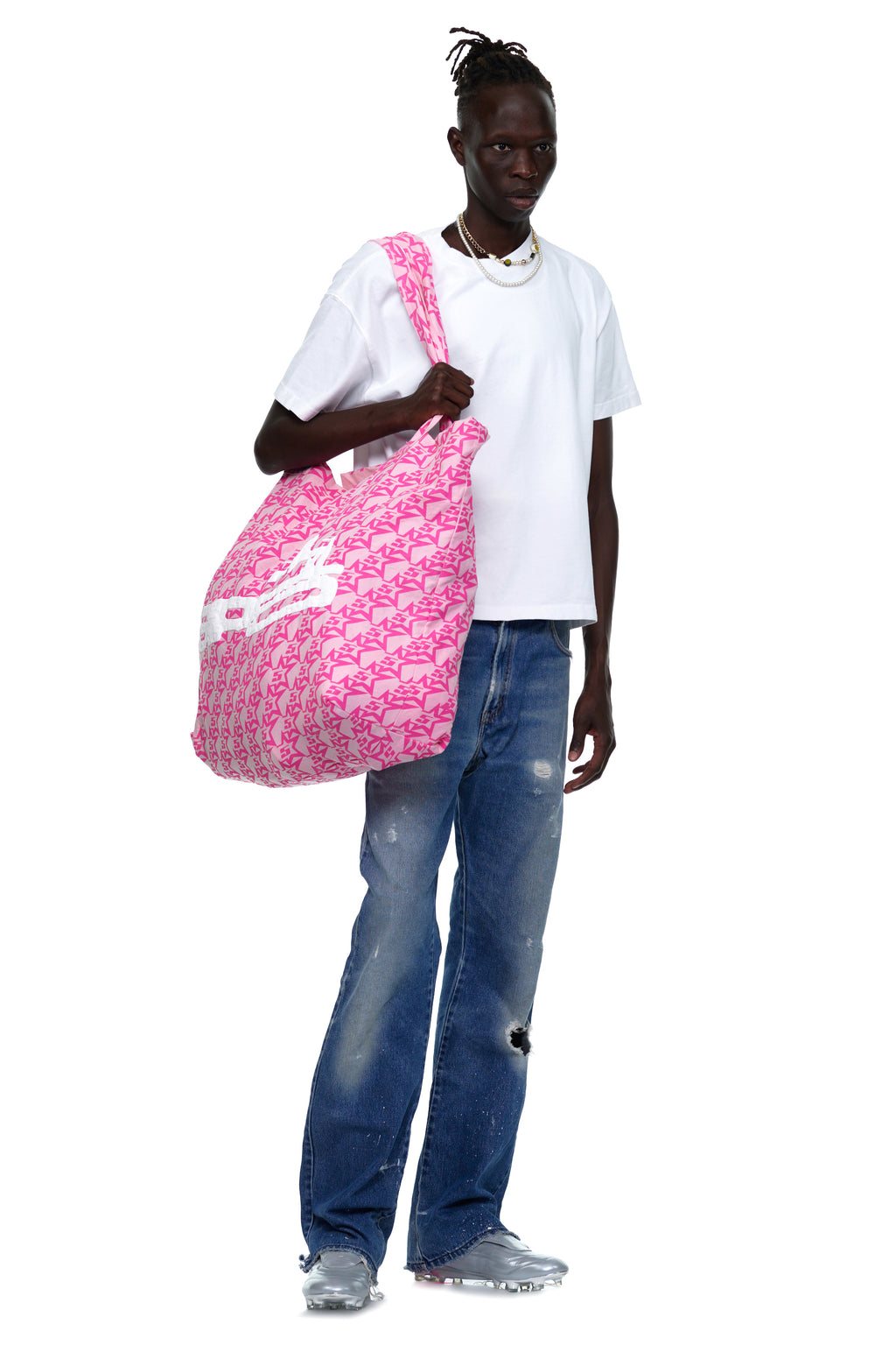 Man holding a large pink brushed twill tote bag with a jumbo print design.