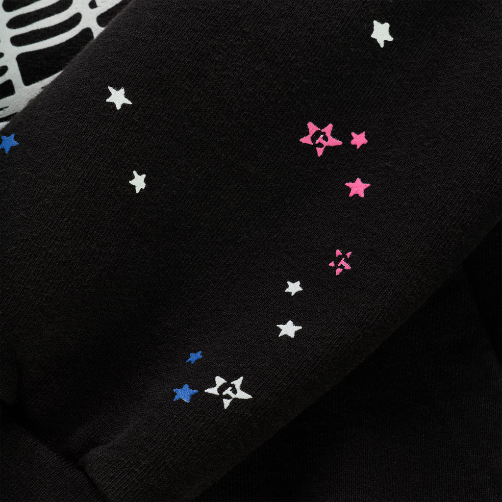Black cotton fleece hoodie sleeve with scattered white, pink, and blue star prints.