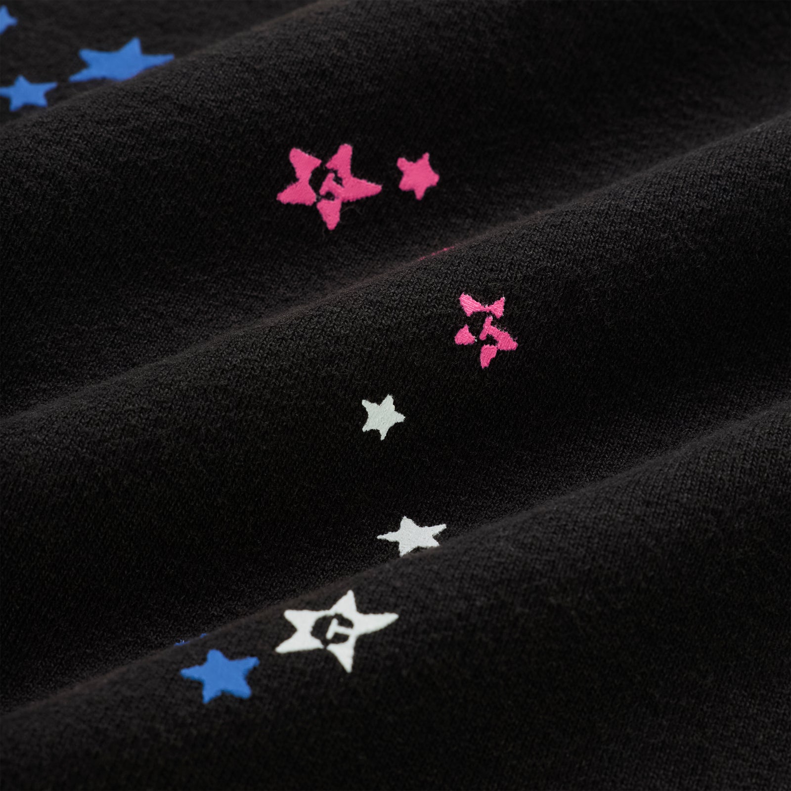 Black cotton fleece hoodie with scattered pink, blue, and white star print.