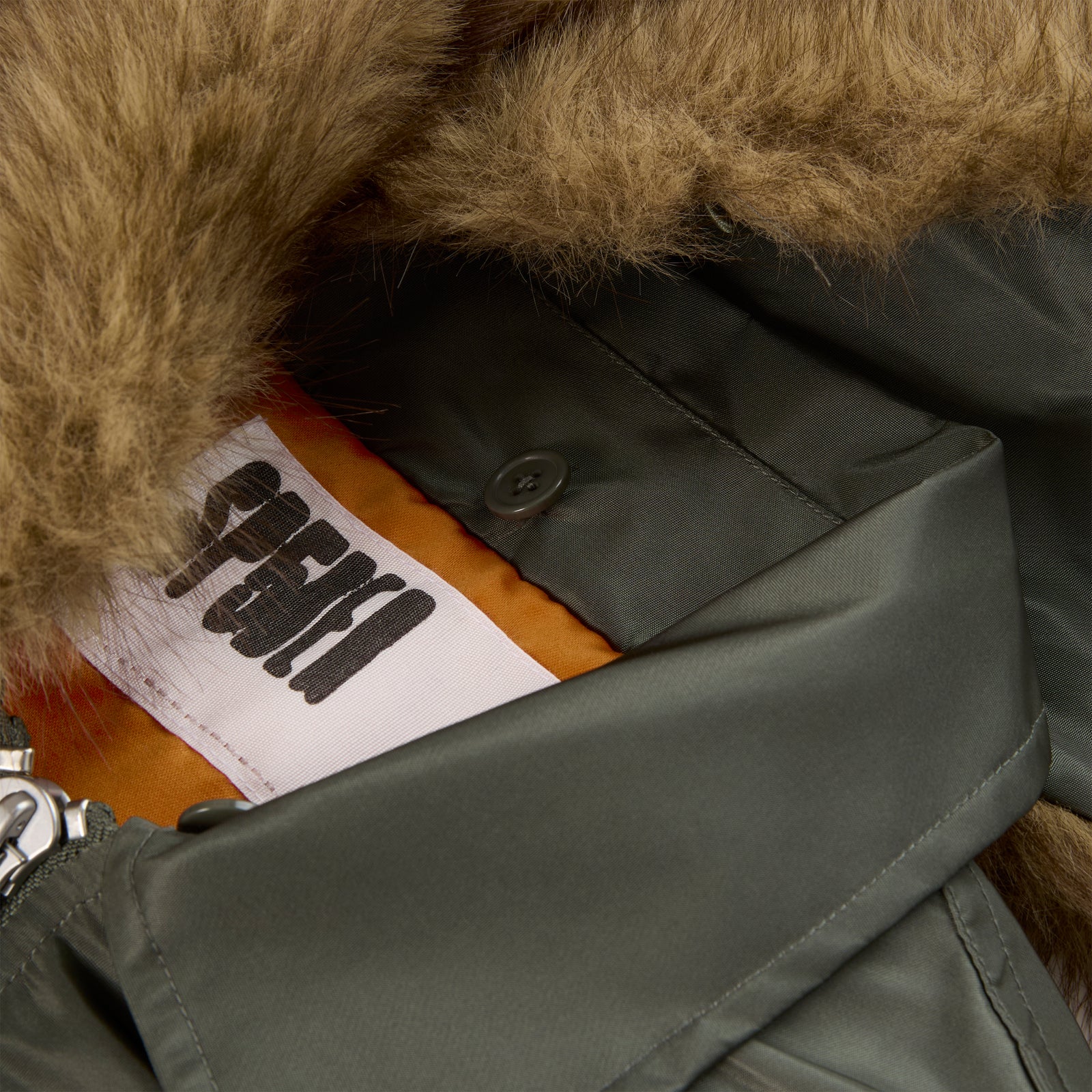 Olive green nylon flight jacket with brown faux fur collar and white SP5DER tag.